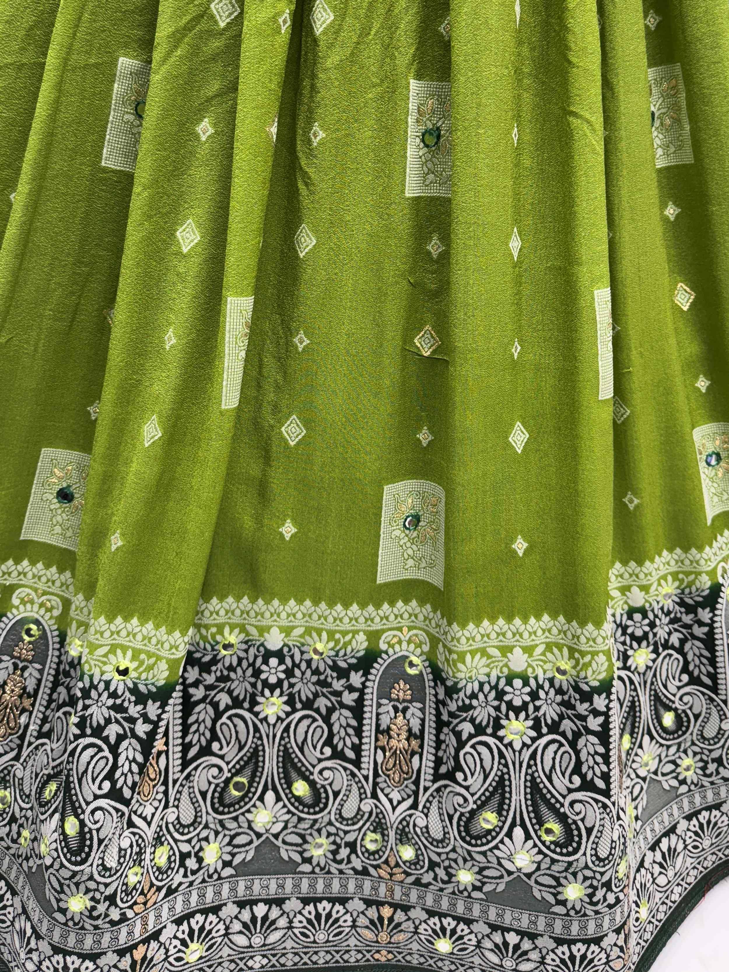 Green ethnic lehenga with black and white paisley border, mirror work, and diamond motifs