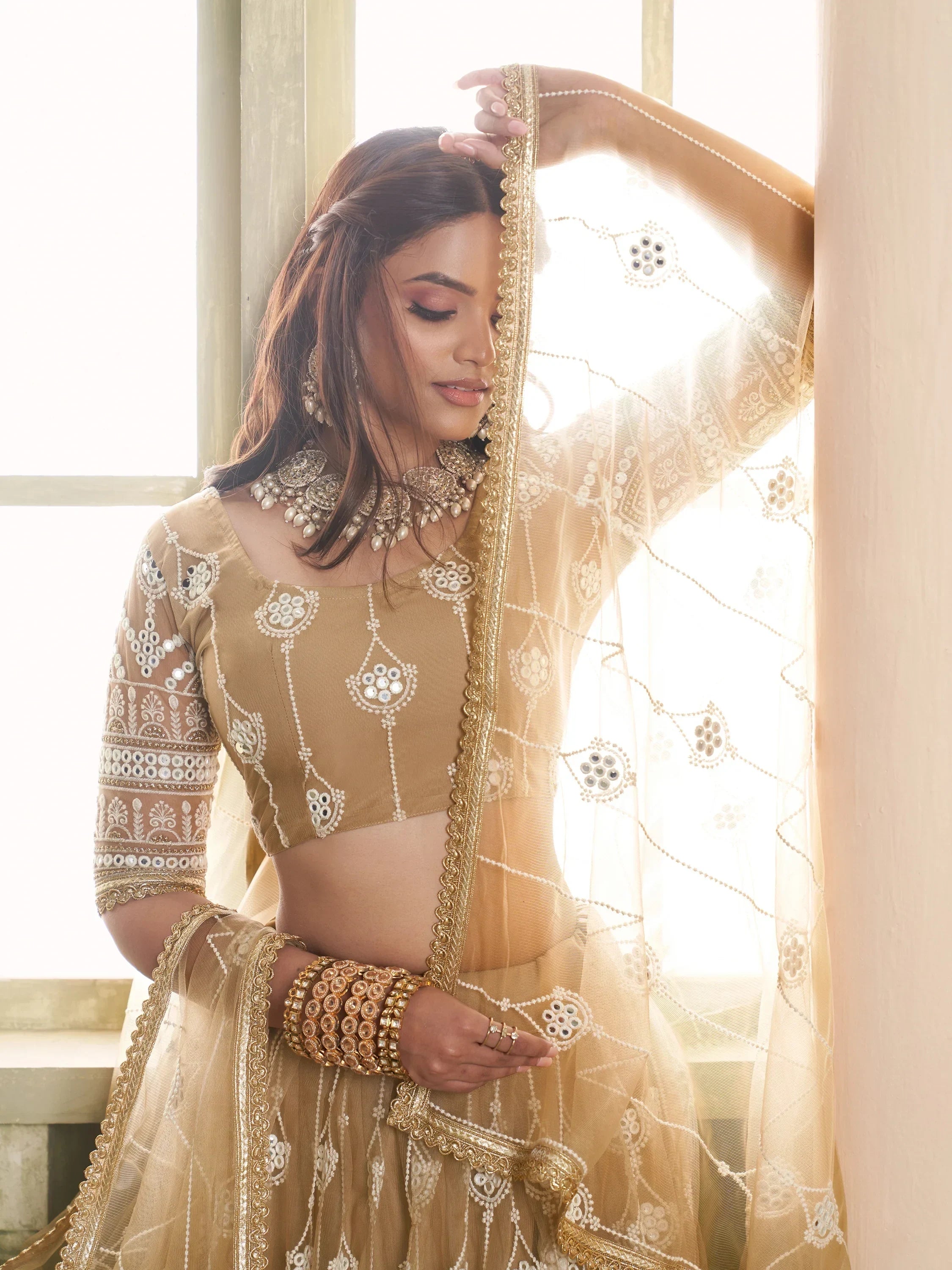 Elegant gold embroidered lehenga choli with mirror work, perfect for Indian ethnic wear and festive occasions.