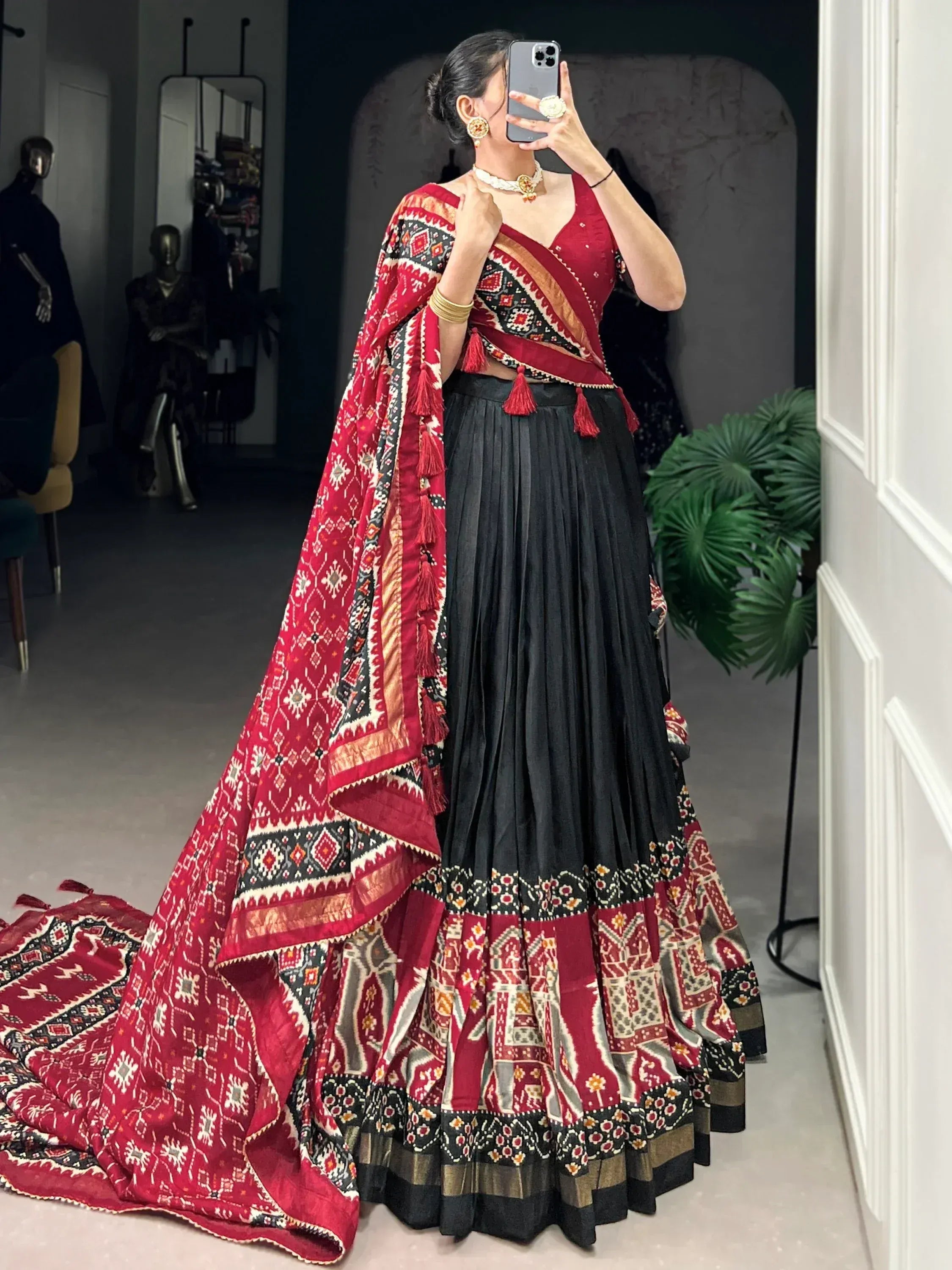 Red and black ethnic lehenga choli with printed dupatta, perfect for Indian weddings and festive occasions.