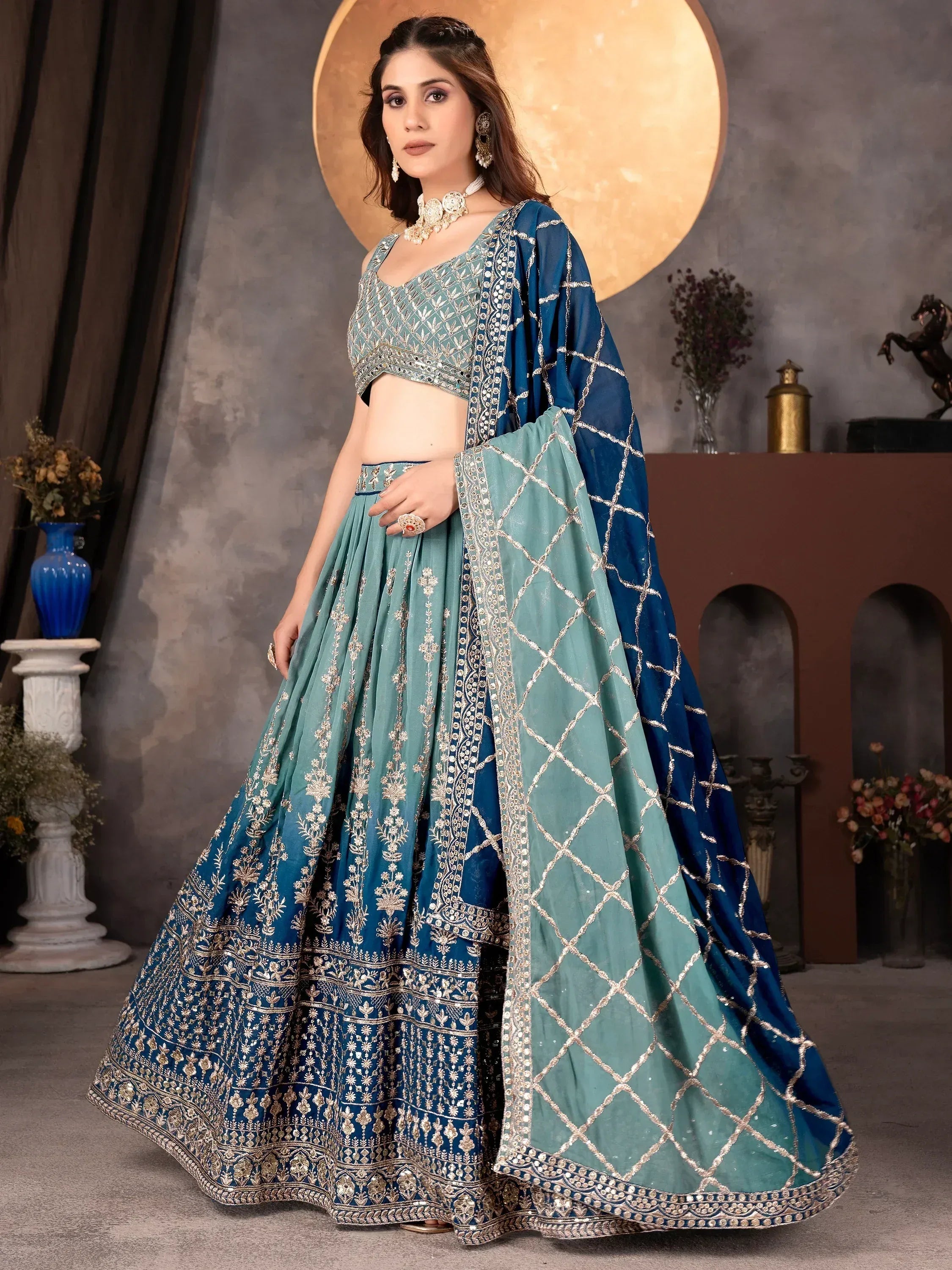 Teal and navy blue designer lehenga choli with gold embroidery, perfect for Indian weddings and festive occasions.