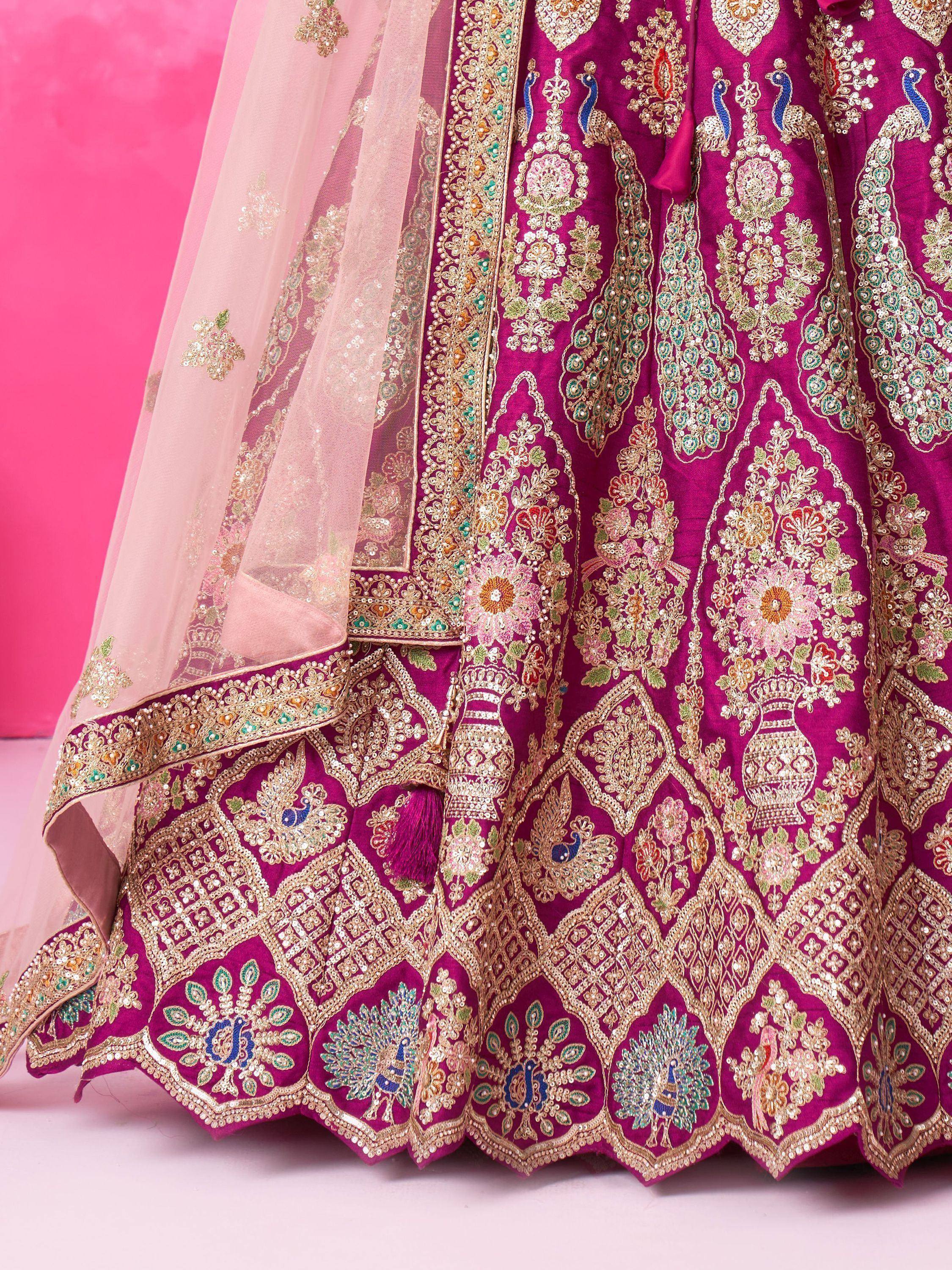 Magenta lehenga choli with peacock embroidery and floral motifs, paired with sheer pink dupatta for Indian ethnic wear.