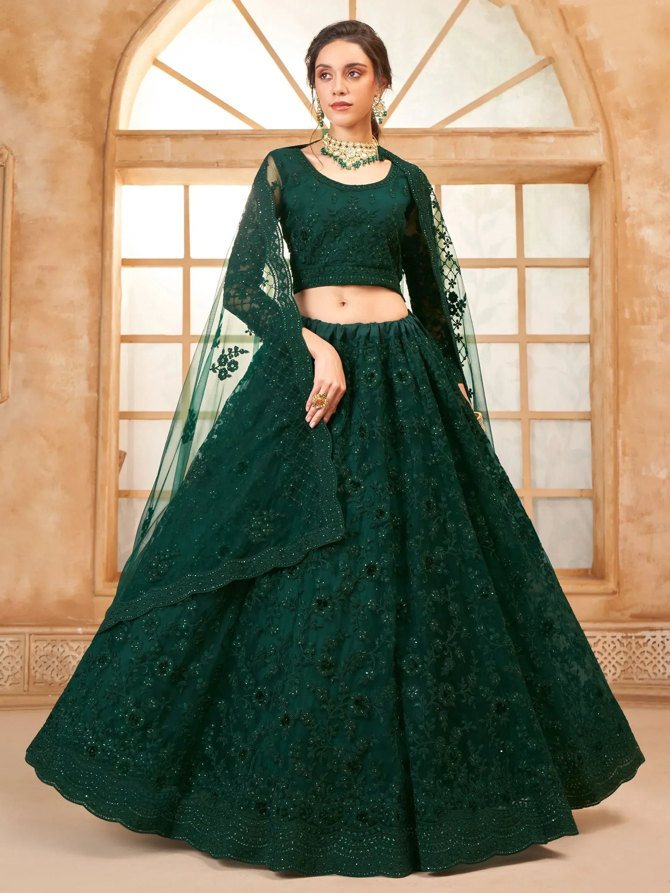 Emerald green designer lehenga choli with intricate embroidery and sheer dupatta, perfect for Indian ethnic occasions.