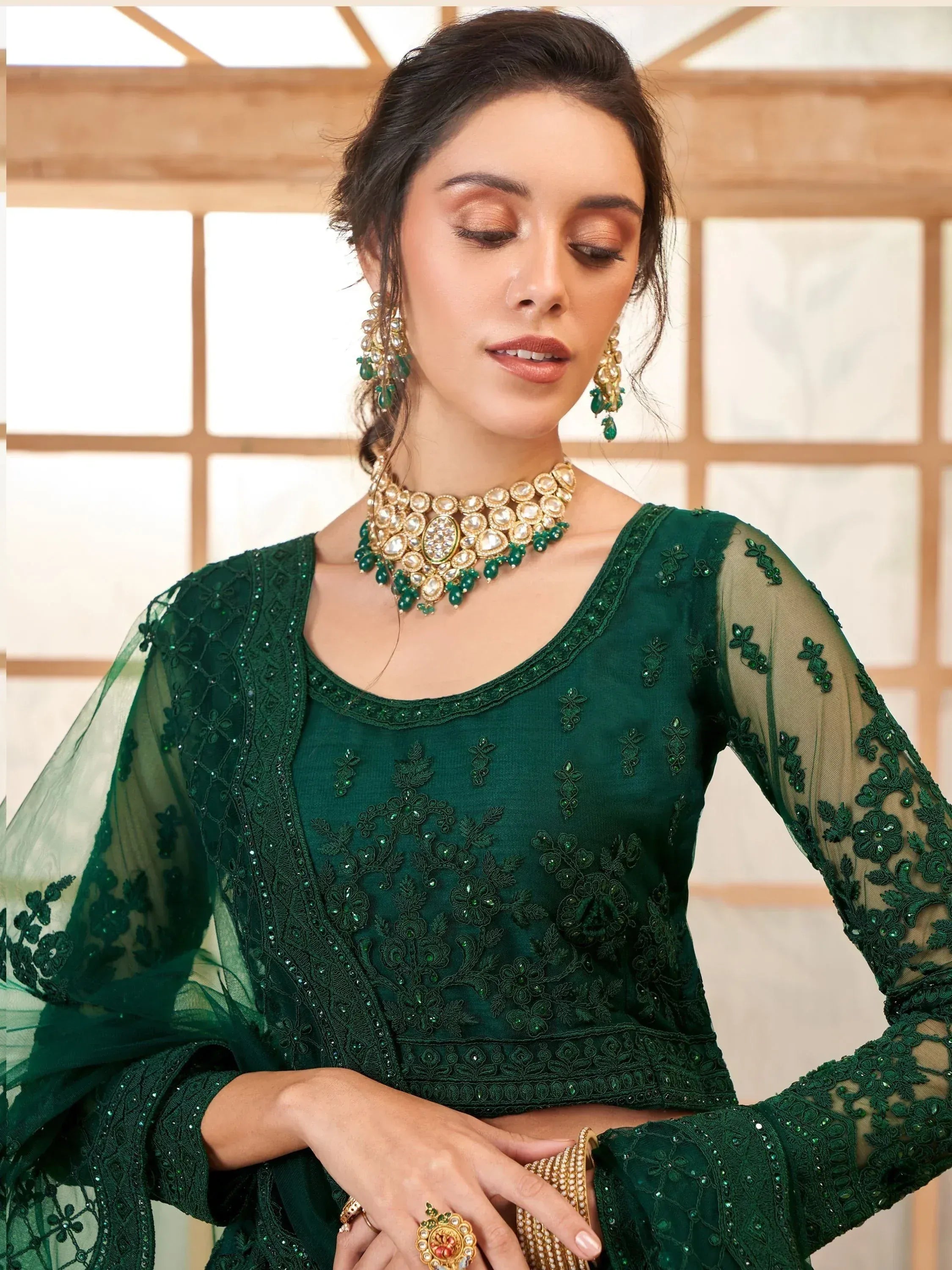 Emerald green embroidered ethnic gown with sheer sleeves and matching jewelry for Indian occasions