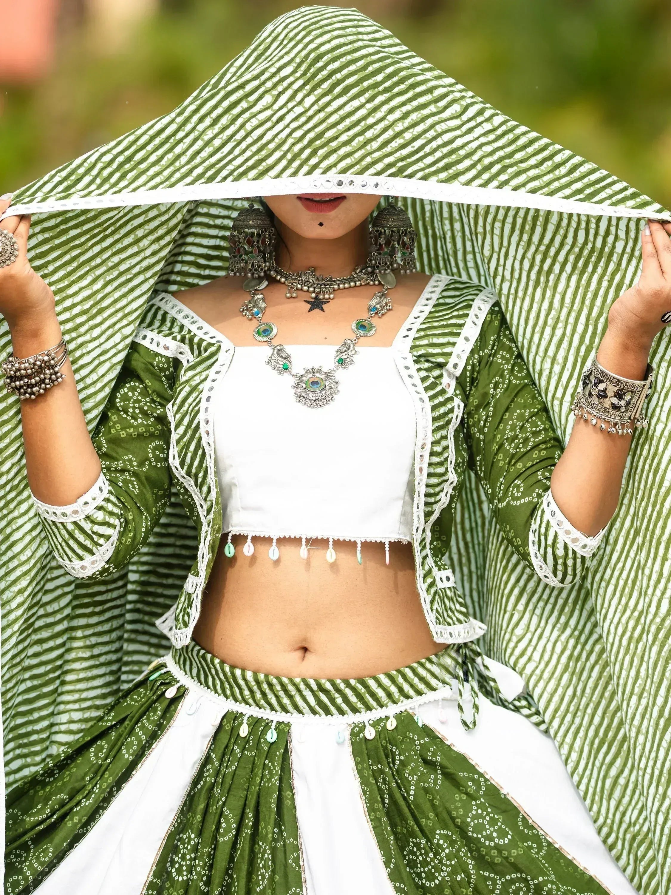 Green and white striped ethnic lehenga choli with mirror work, paired with traditional jewelry and dupatta.