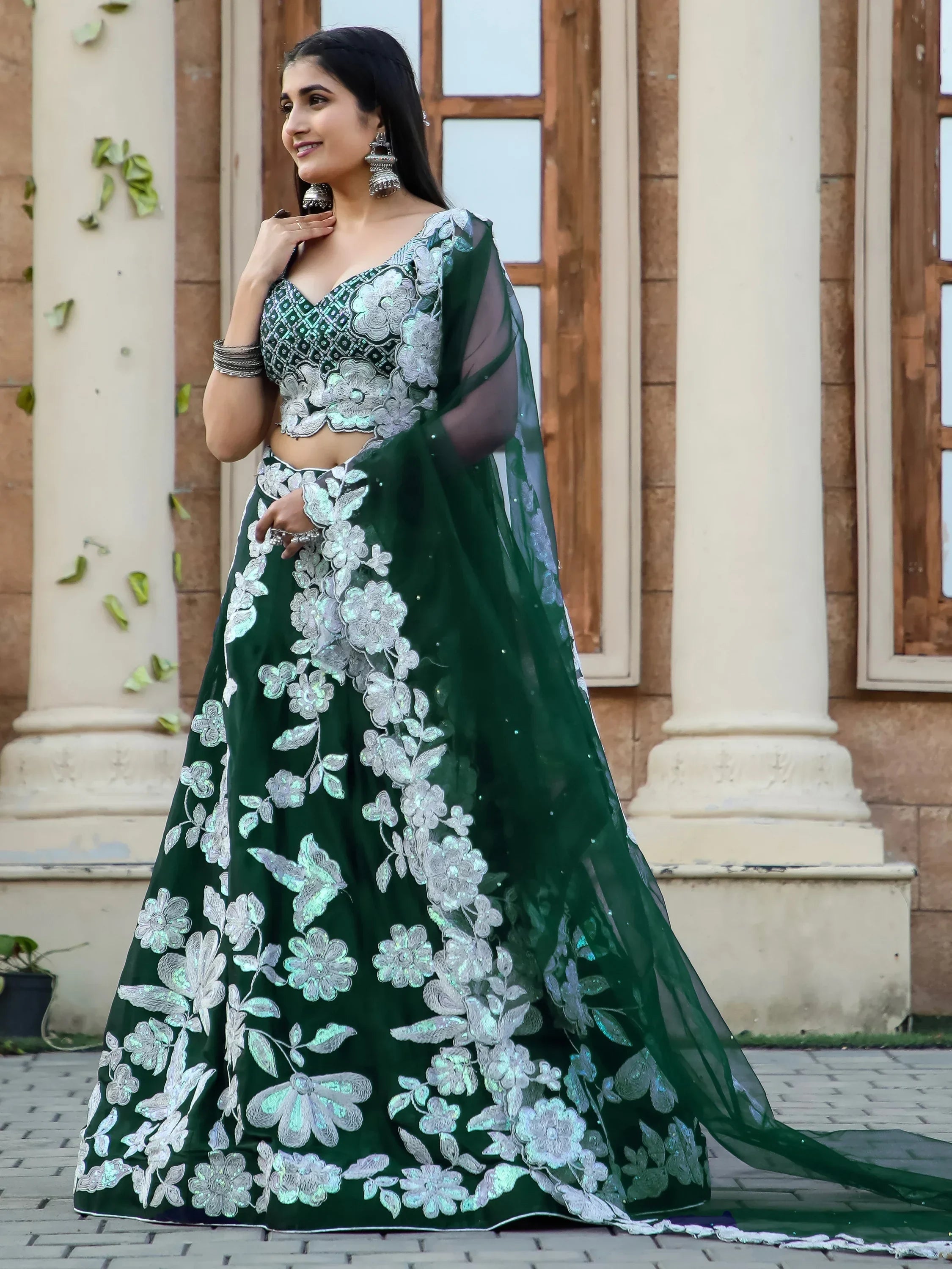 Emerald green lehenga choli with silver floral embroidery, perfect for Indian weddings and festive occasions.