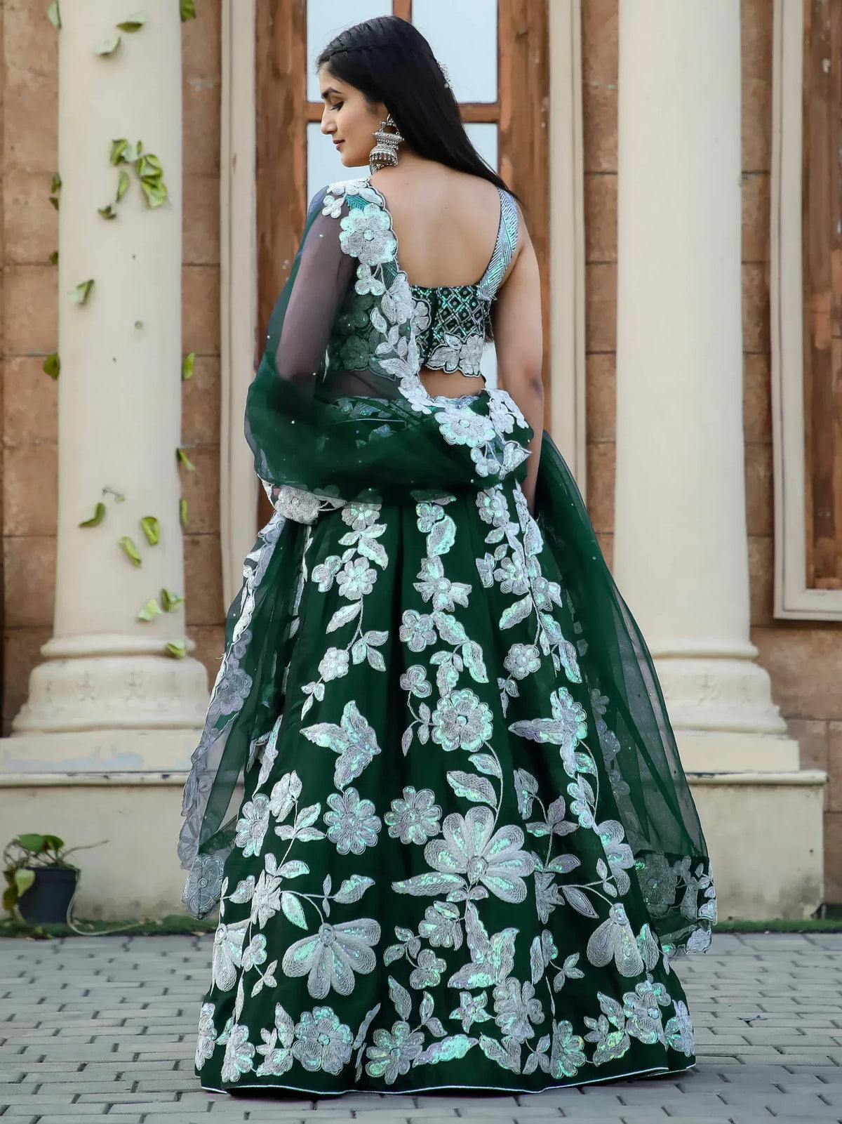 Emerald green designer lehenga choli with silver floral embroidery, perfect for Indian weddings and festive occasions.