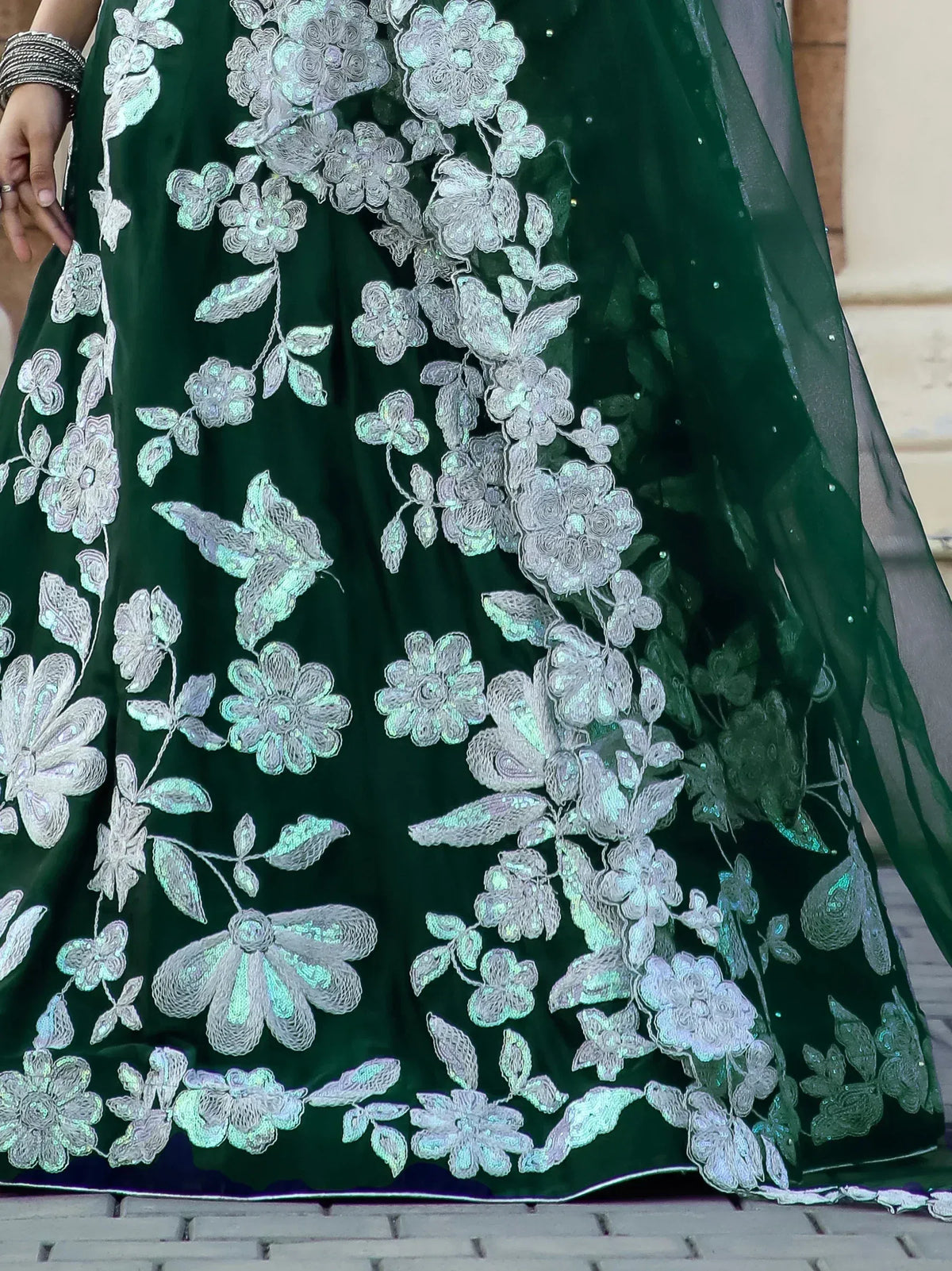 Emerald green velvet lehenga with silver floral embroidery and sequin detailing, perfect for Indian ethnic wear.