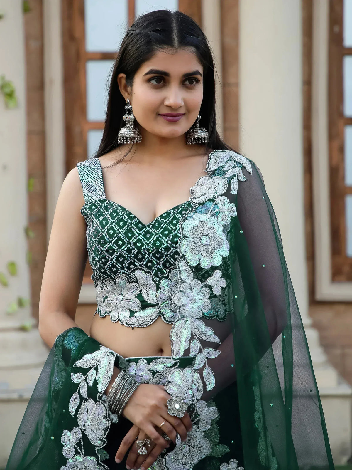 Emerald green lehenga choli with silver floral embroidery and sheer dupatta, perfect for Indian ethnic wear events