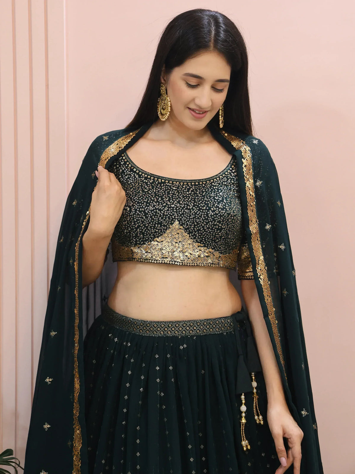 Emerald green sequined lehenga choli with gold embroidery and matching dupatta, perfect for Indian ethnic wear events.