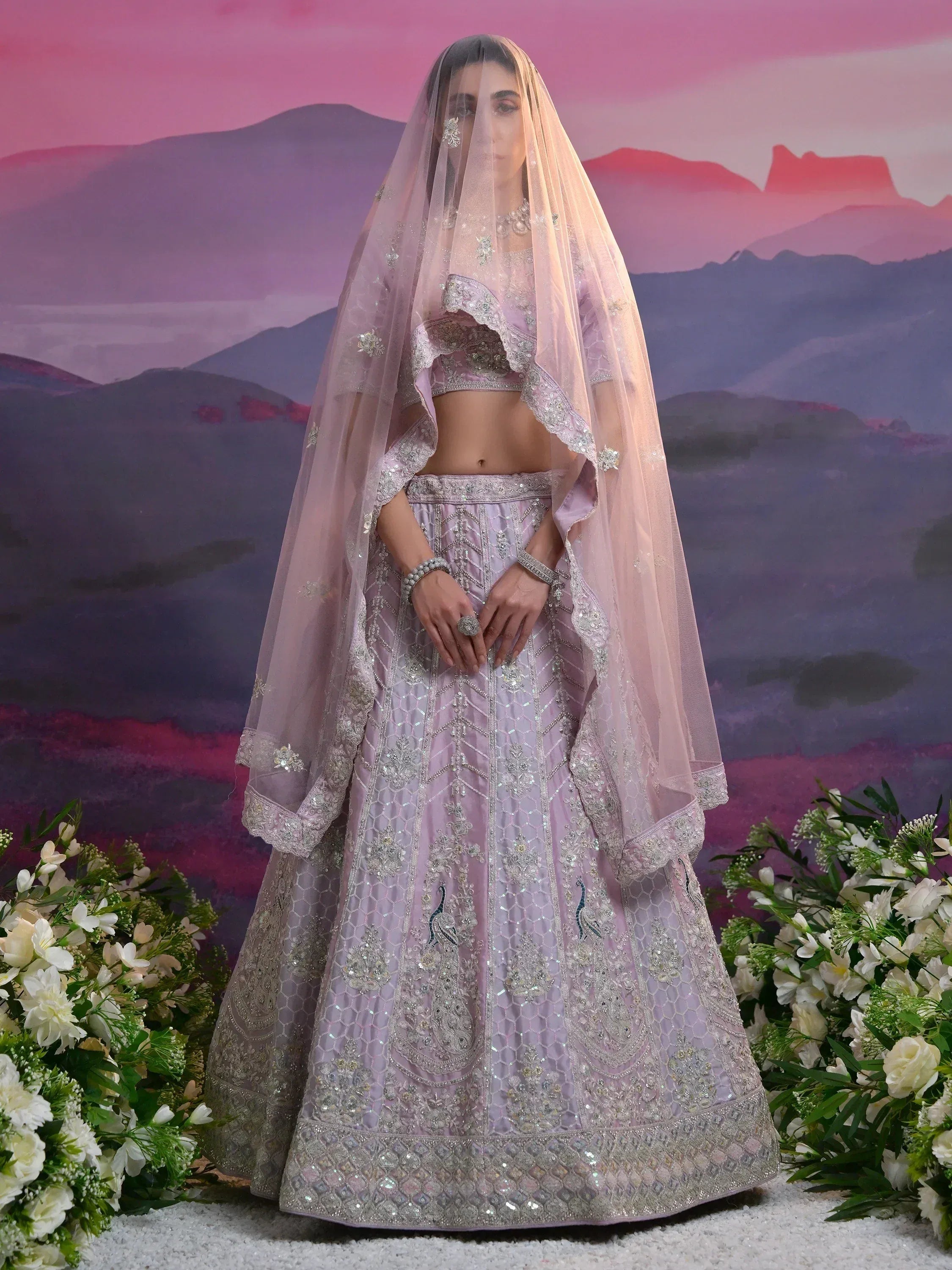 Elegant lavender lehenga choli with heavy embroidery, peacock motifs, and sheer dupatta for Indian weddings