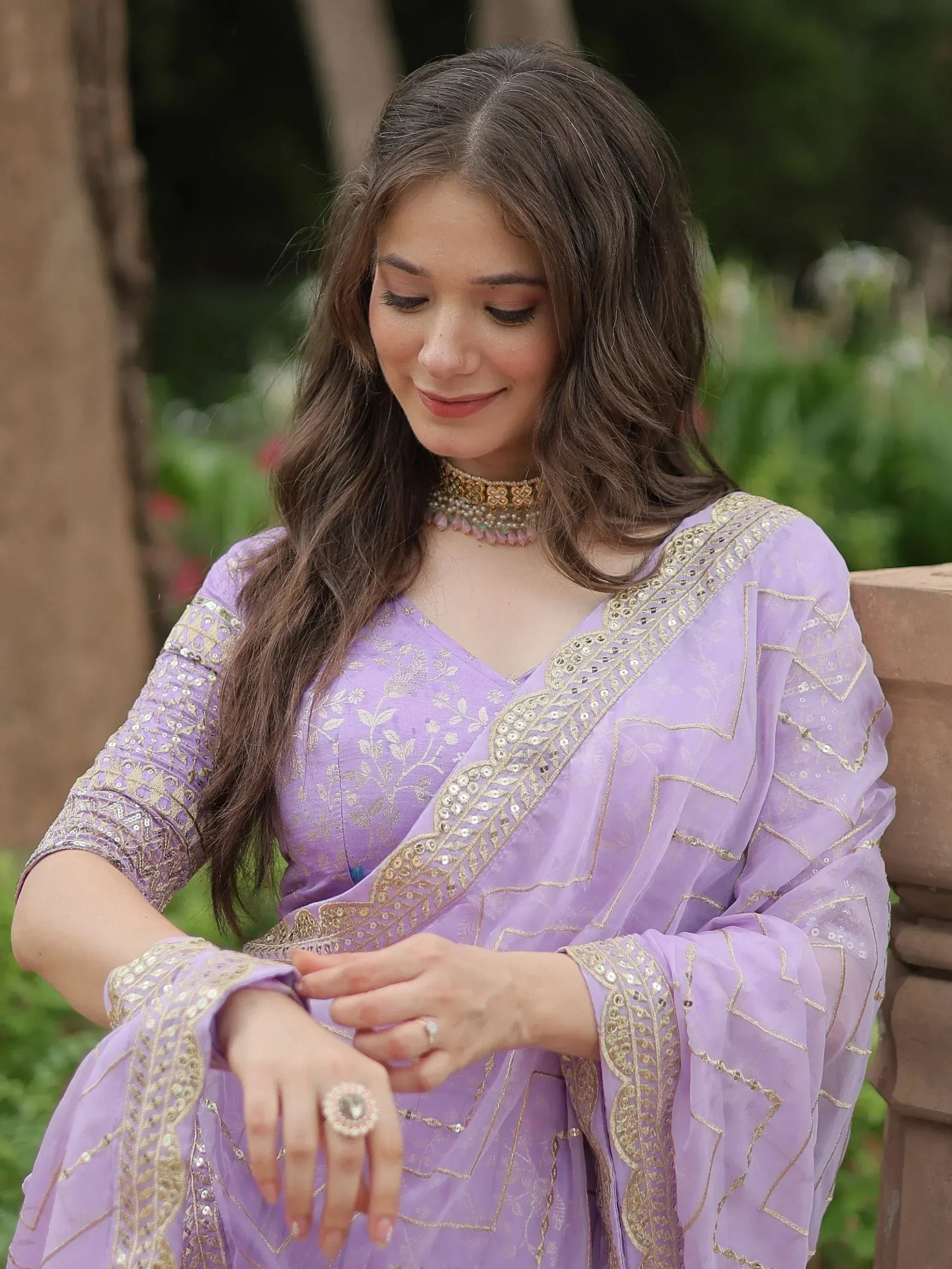 Woman in lavender ethnic gown with gold embroidery, perfect for Indian occasions