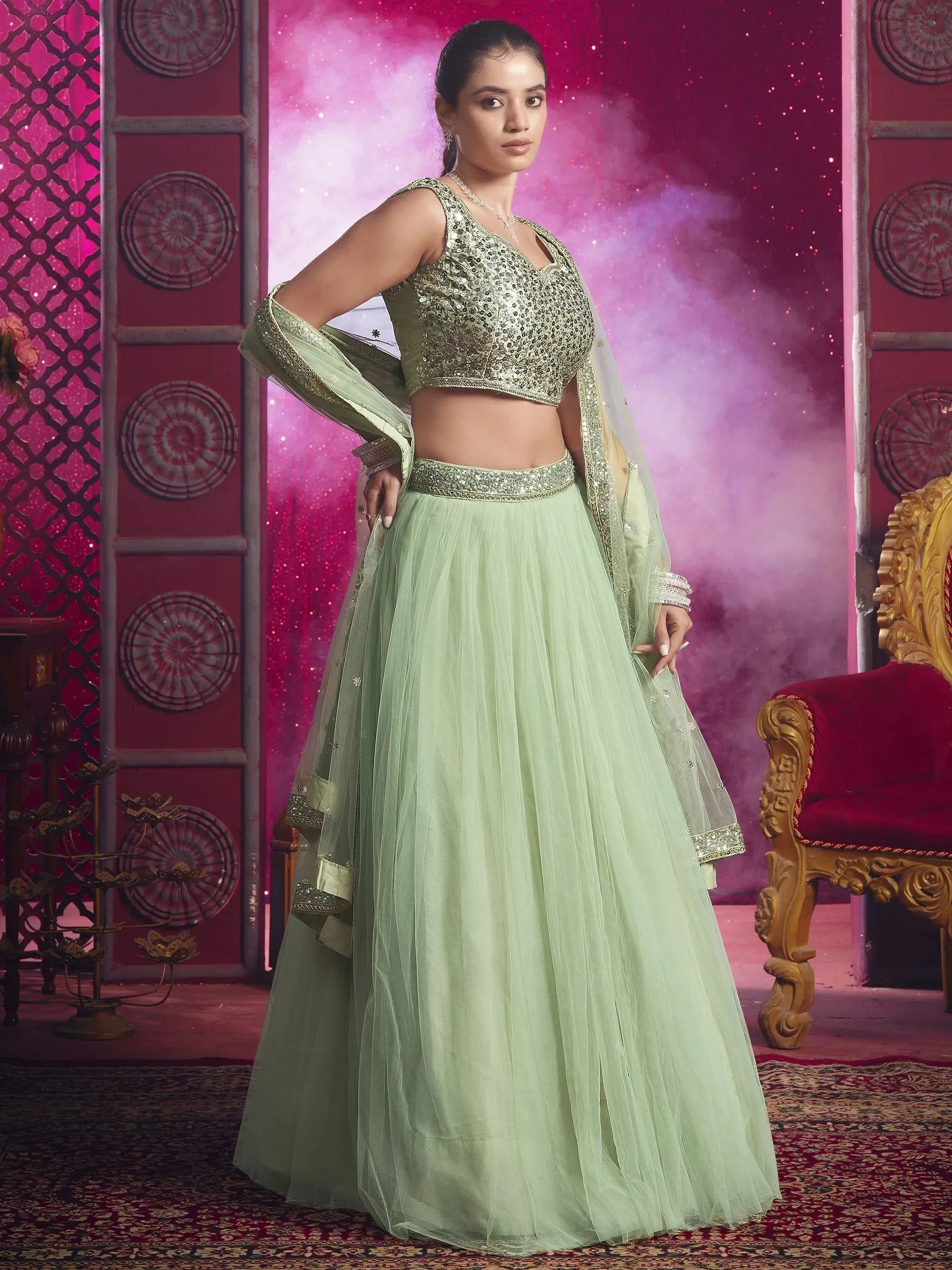 Mint green designer lehenga choli with sequin blouse and net skirt, perfect for Indian ethnic wear occasions.
