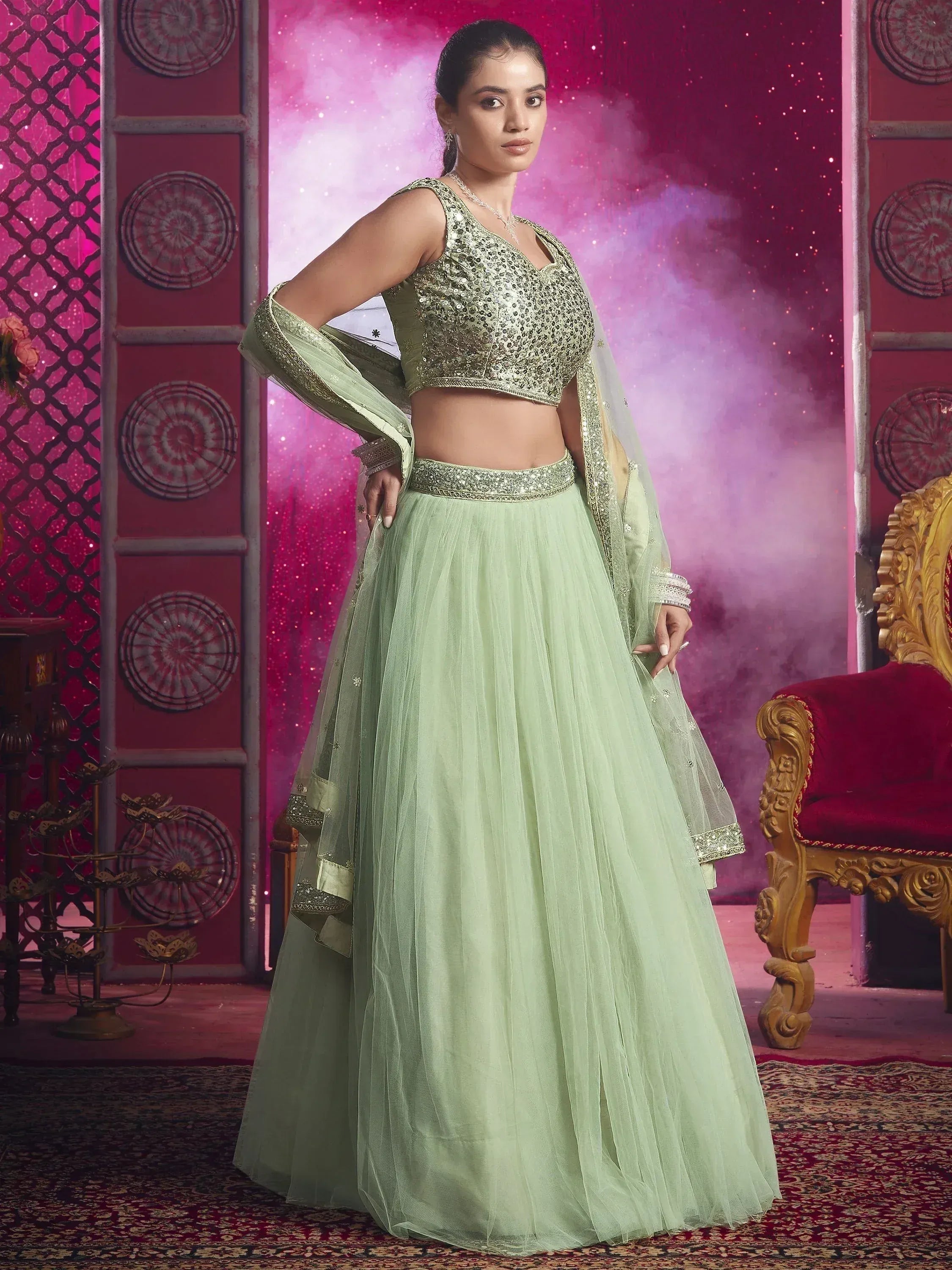Mint green designer lehenga choli with sequin blouse and net skirt, perfect for Indian ethnic wear occasions.