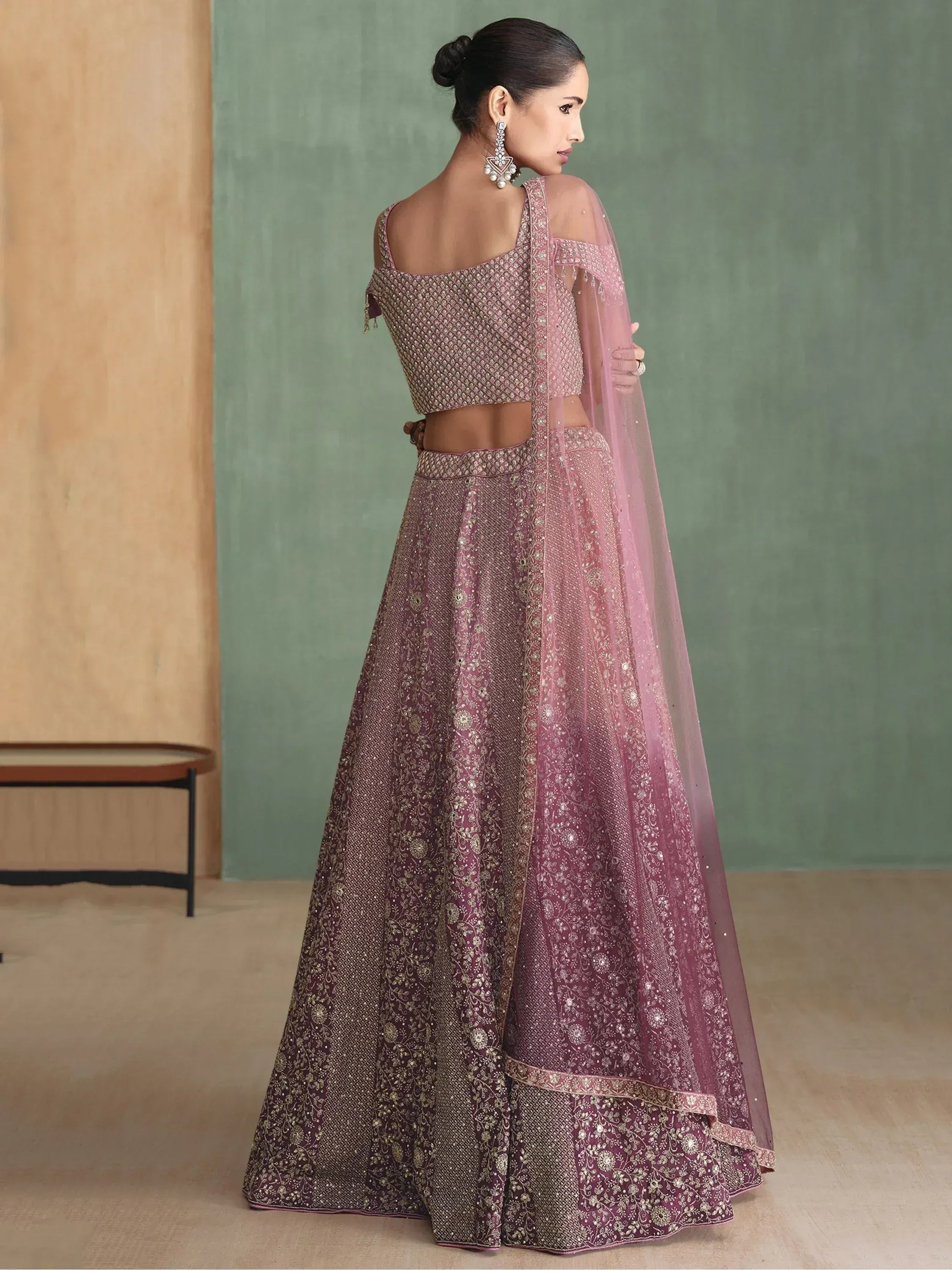 Elegant mauve lehenga choli with gold embroidery, sheer dupatta, and off-shoulder blouse for Indian ethnic wear
