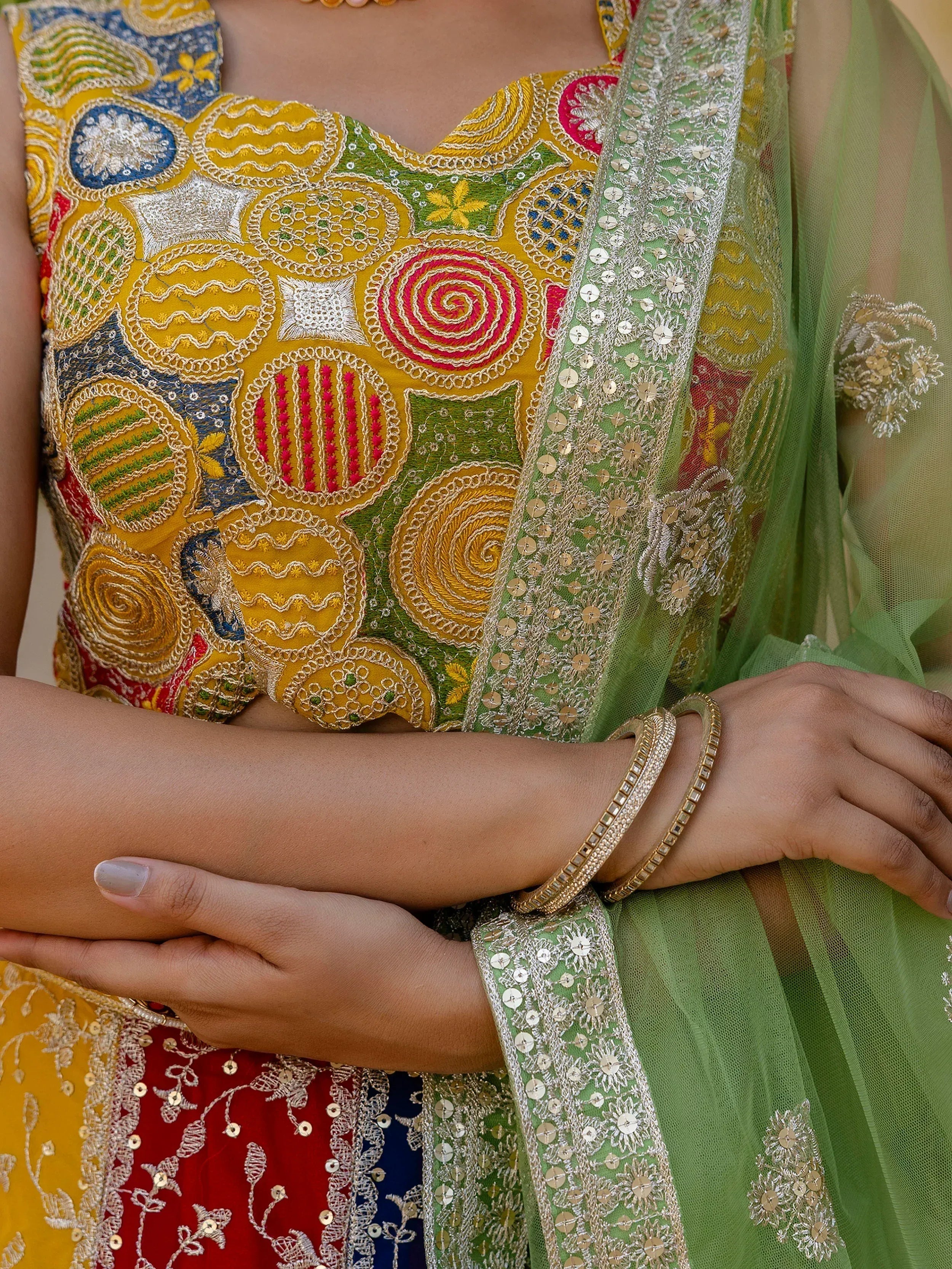 Vibrant yellow and green embroidered Indian ethnic wear with intricate patchwork and sequin dupatta