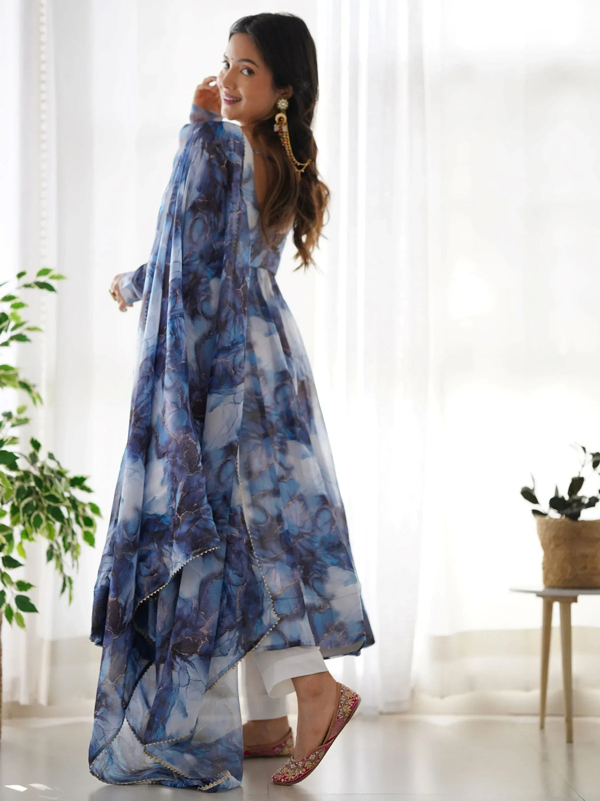 Woman in blue floral printed ethnic gown with white palazzo and embroidered flats
