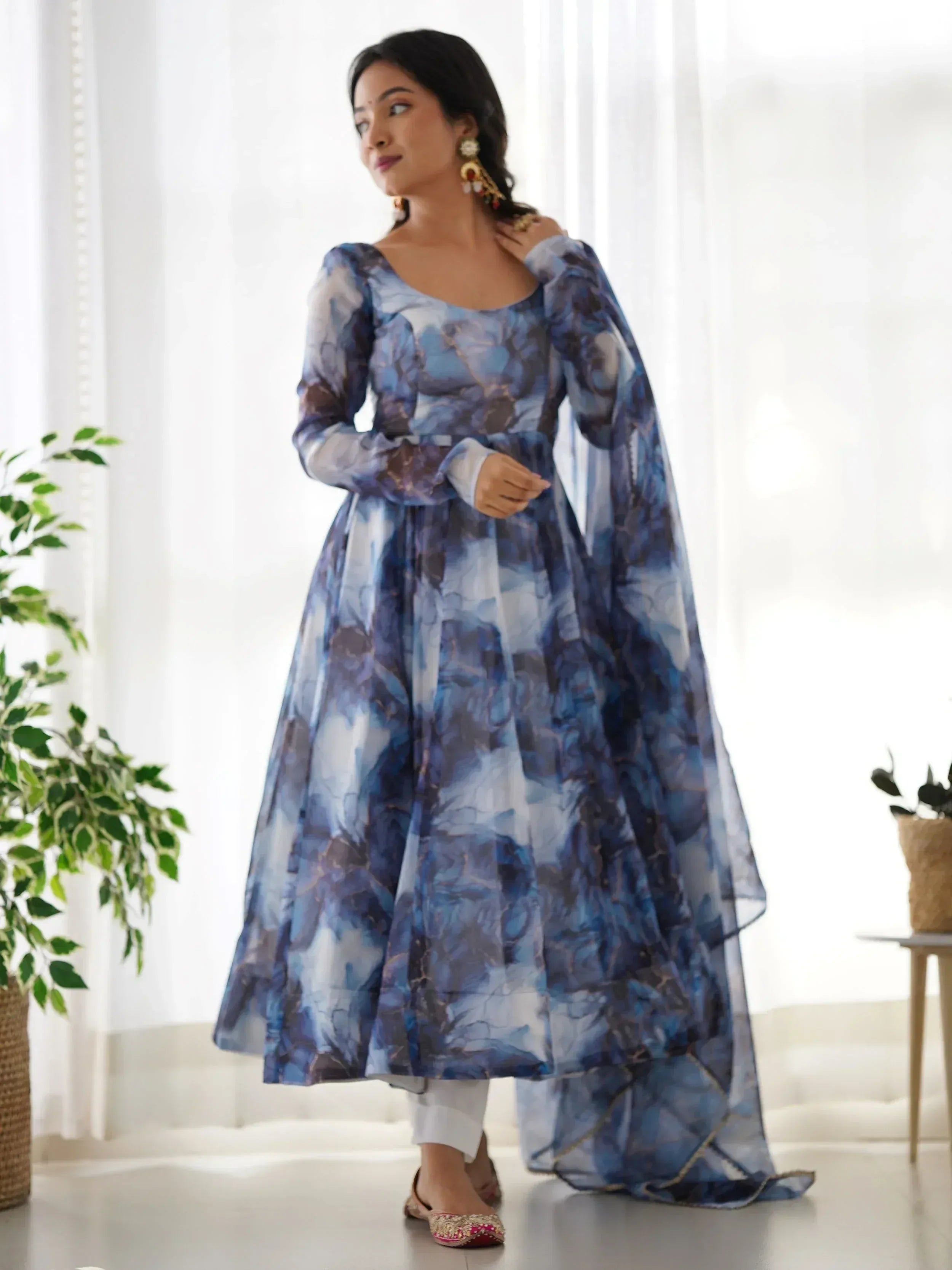 Blue floral print ethnic gown with sheer cape, styled with white pants and juttis for Indian wear