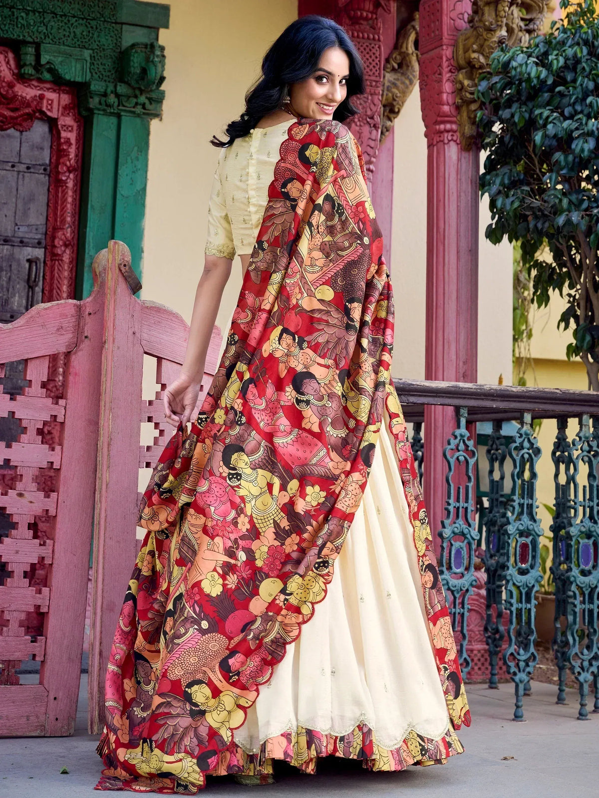 Woman in cream lehenga choli with vibrant red printed dupatta, ethnic Indian wear