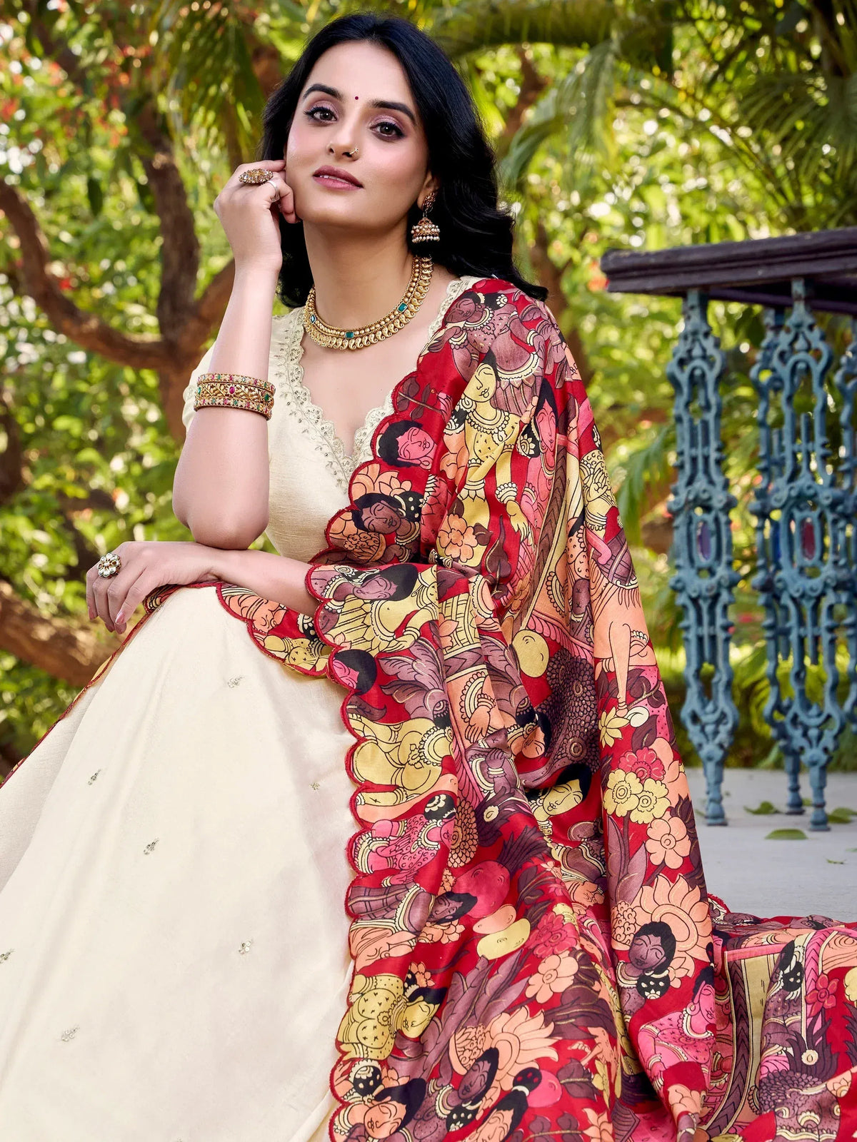 Woman in cream designer lehenga choli with vibrant red printed dupatta, traditional Indian ethnic wear