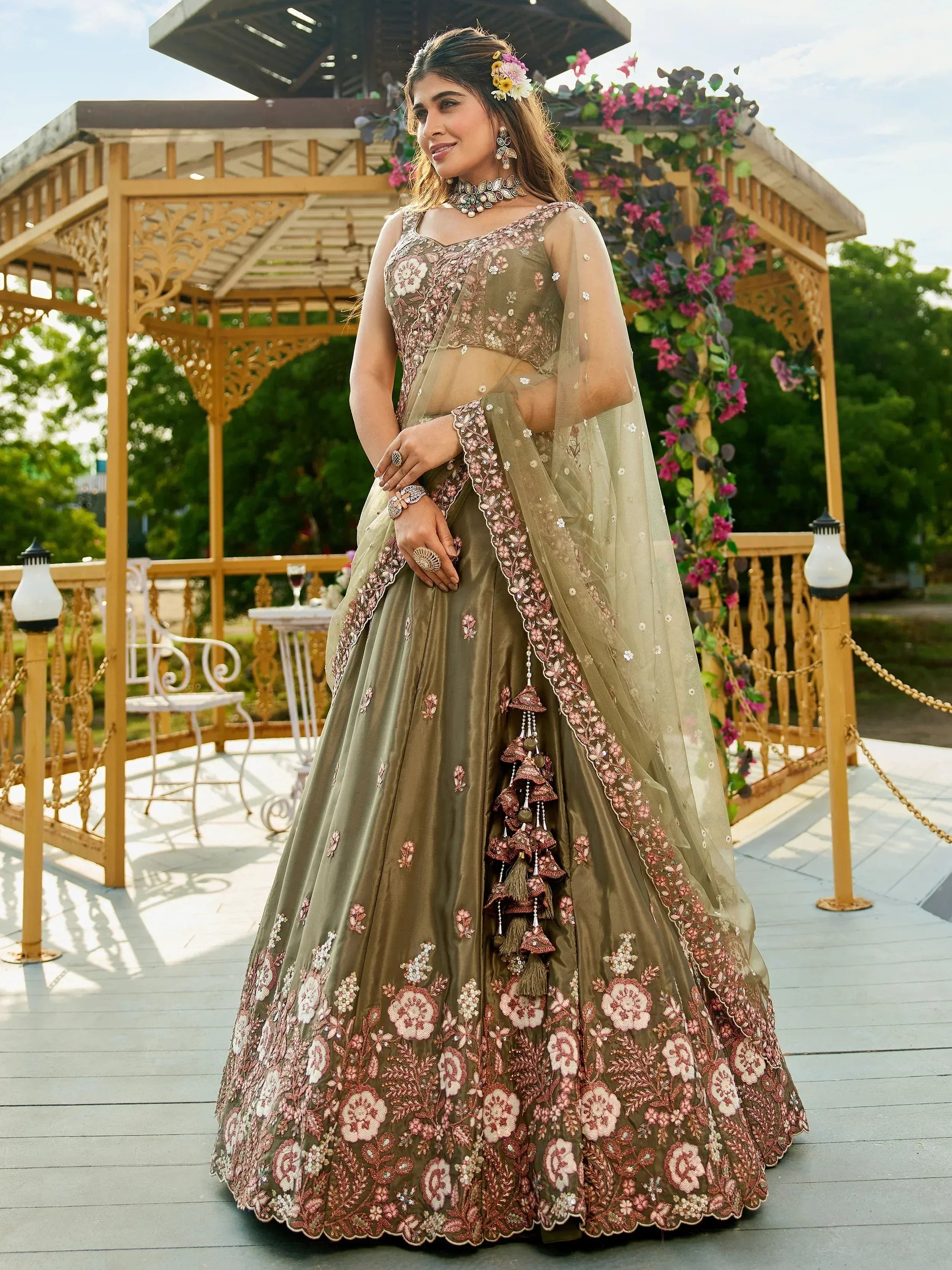 Olive green designer lehenga choli with pink floral embroidery and tassels, perfect for weddings and ethnic events.
