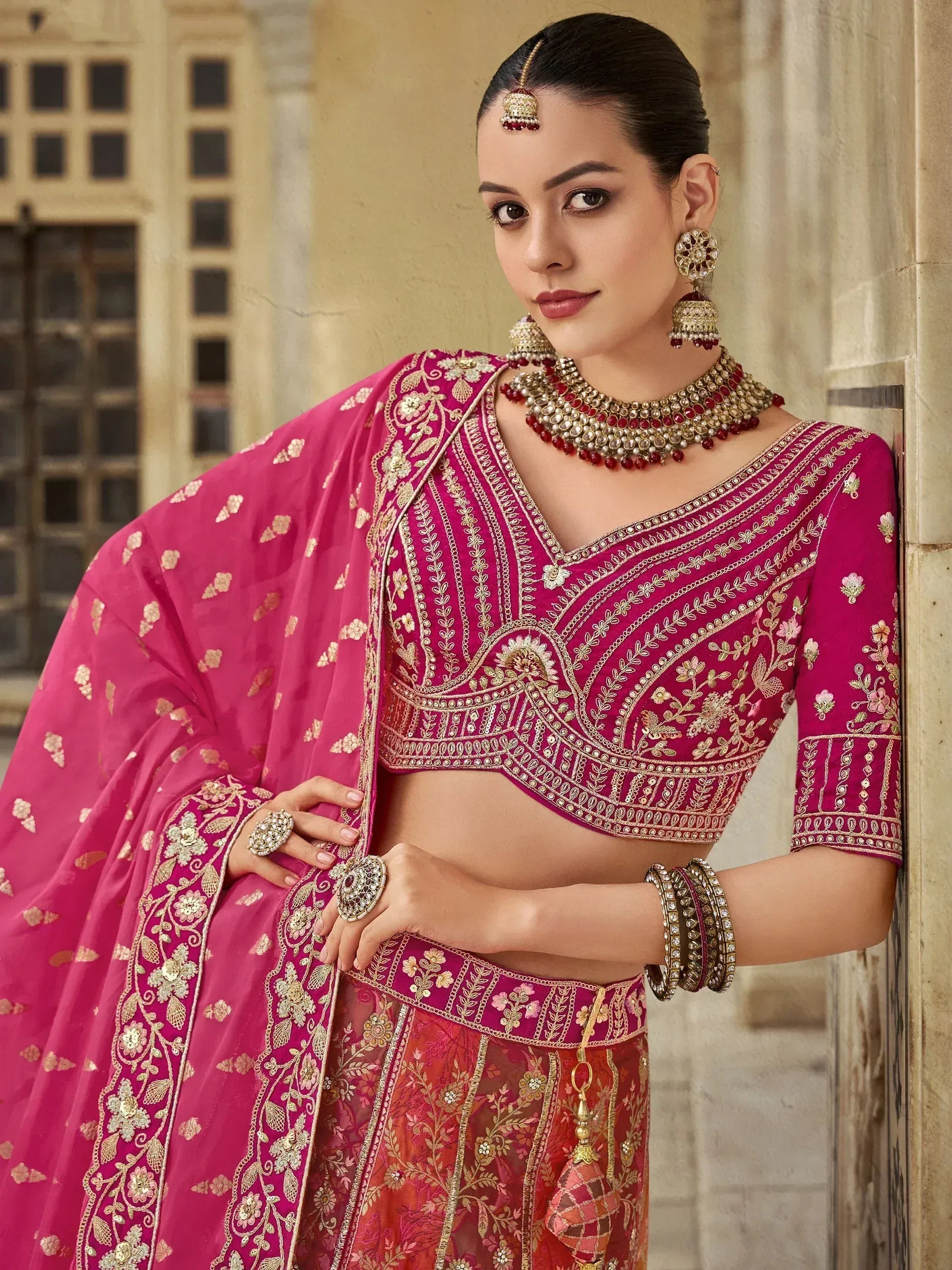 Pink embroidered lehenga choli with gold detailing, perfect for Indian weddings and festive occasions.