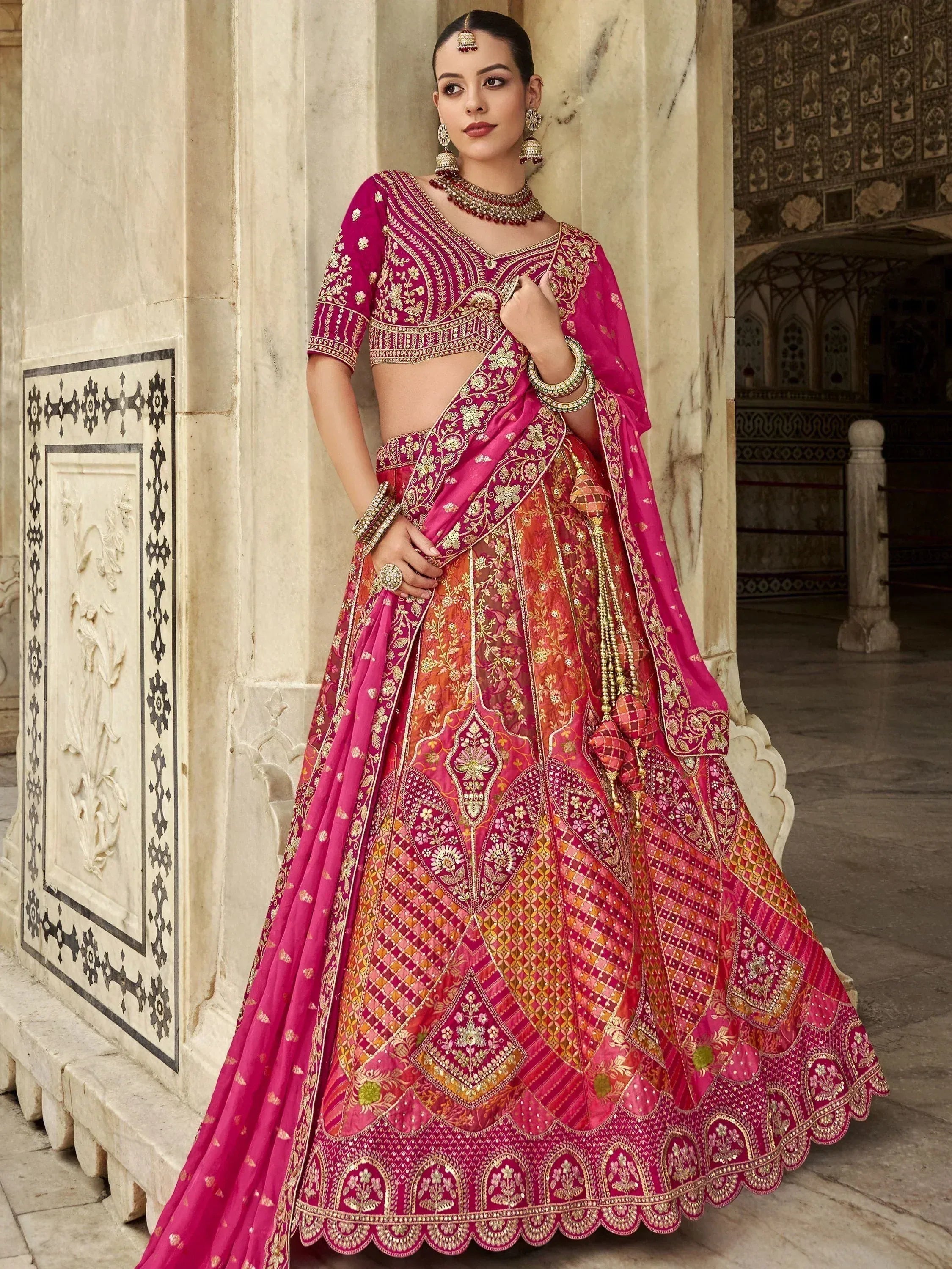 Pink and gold embroidered lehenga choli with intricate floral patterns, perfect for Indian weddings and festive occasions.