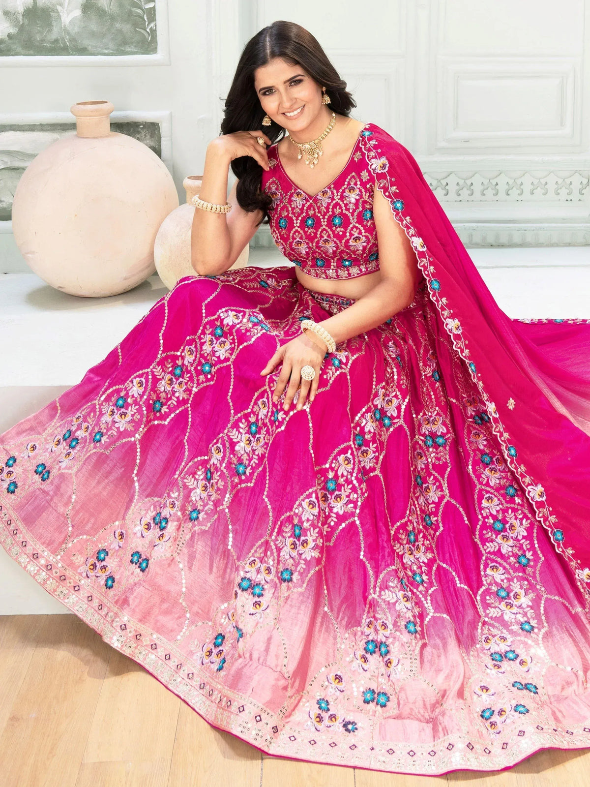 Pink embroidered lehenga choli with floral motifs, perfect for Indian weddings and festive occasions.