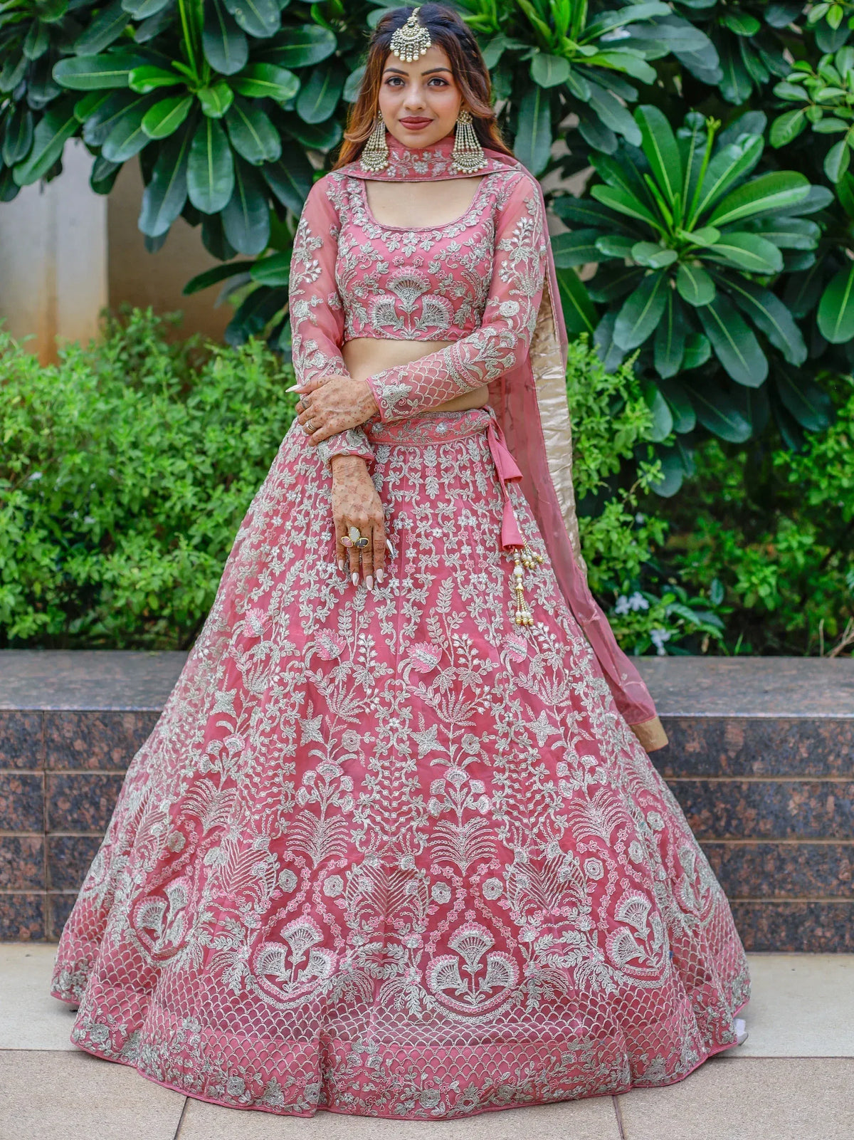 Pink embroidered lehenga choli with silver floral work, perfect for Indian weddings and festive occasions.