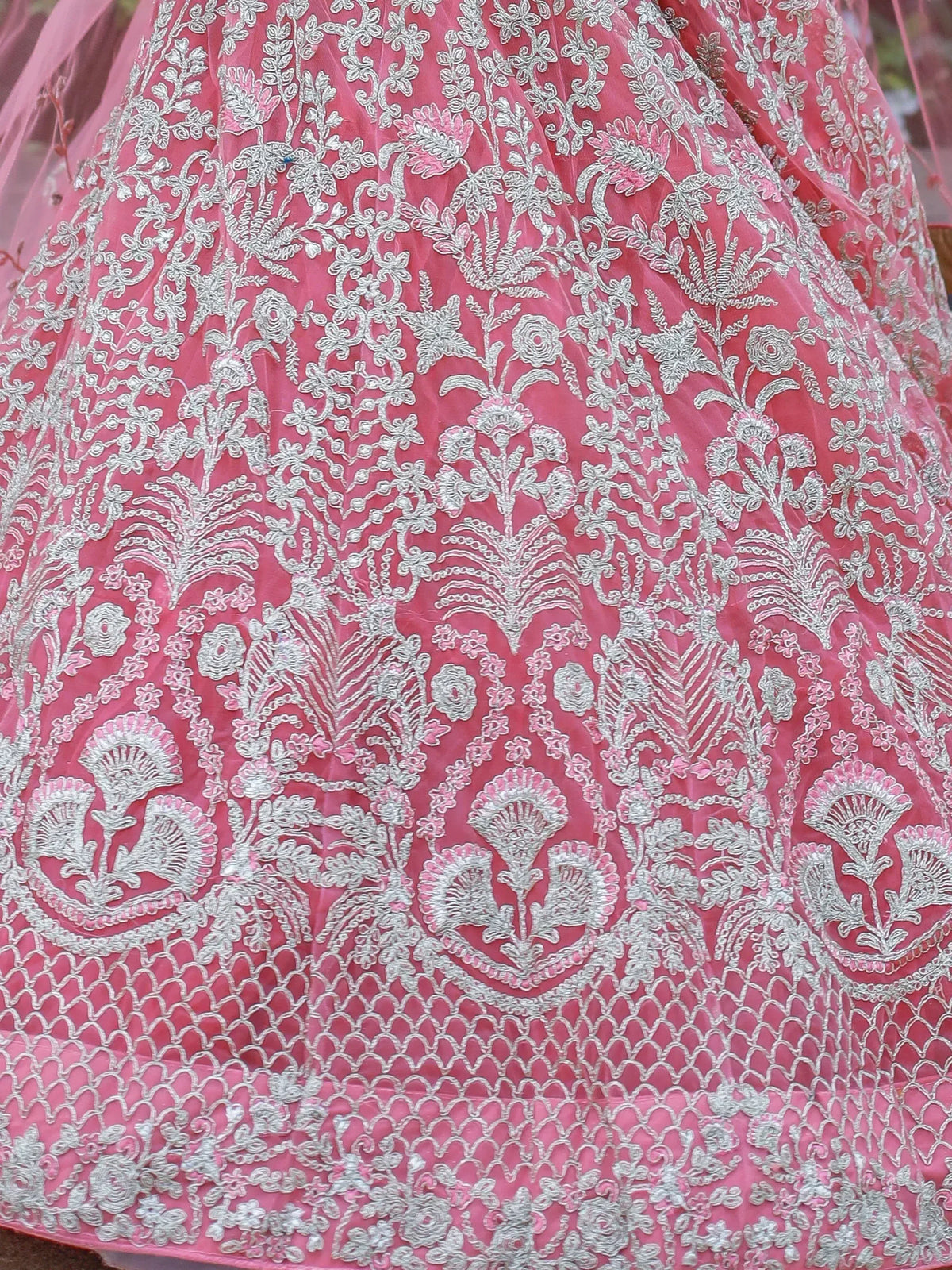 Pink lehenga with silver floral embroidery and net detailing, ideal for Indian ethnic wear occasions.
