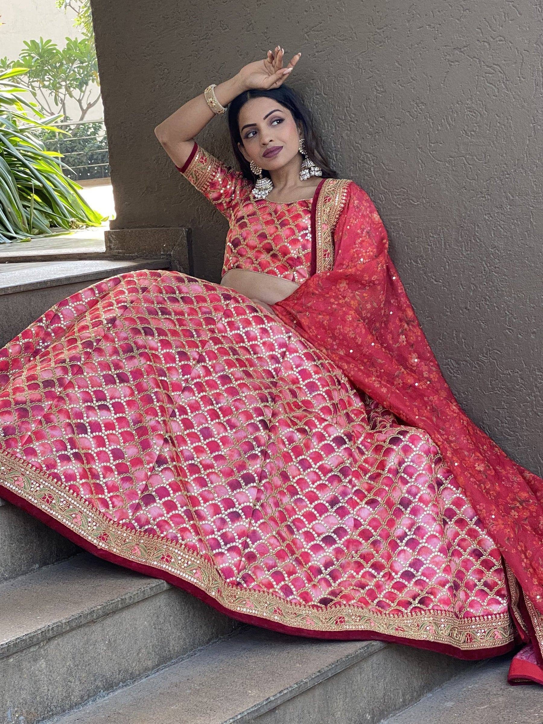 Red designer lehenga choli with gold embroidery, perfect for Indian weddings and festive occasions.