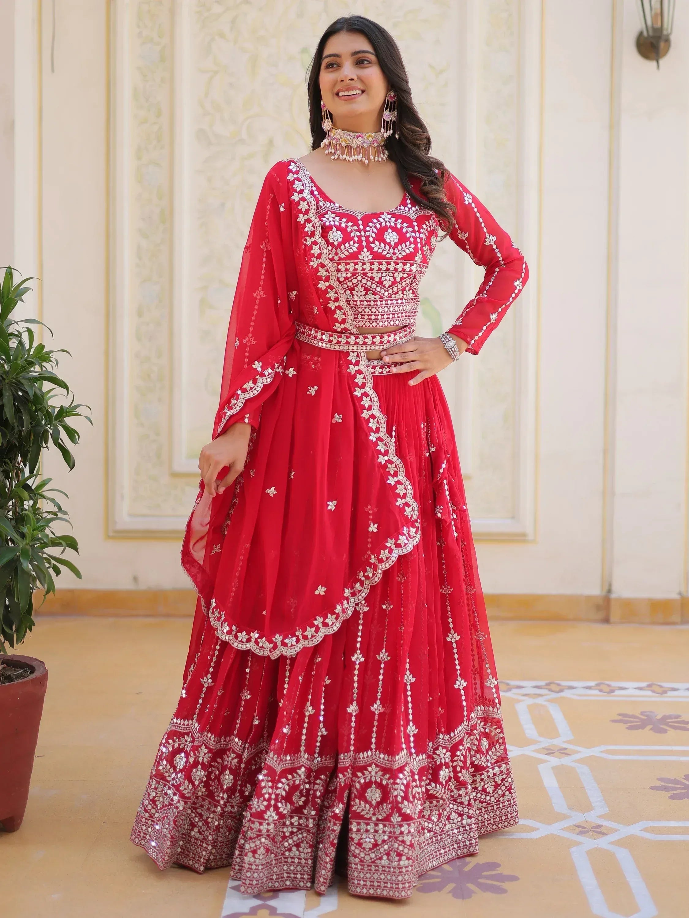 Red embroidered lehenga choli with floral motifs, perfect for Indian weddings and festive occasions.
