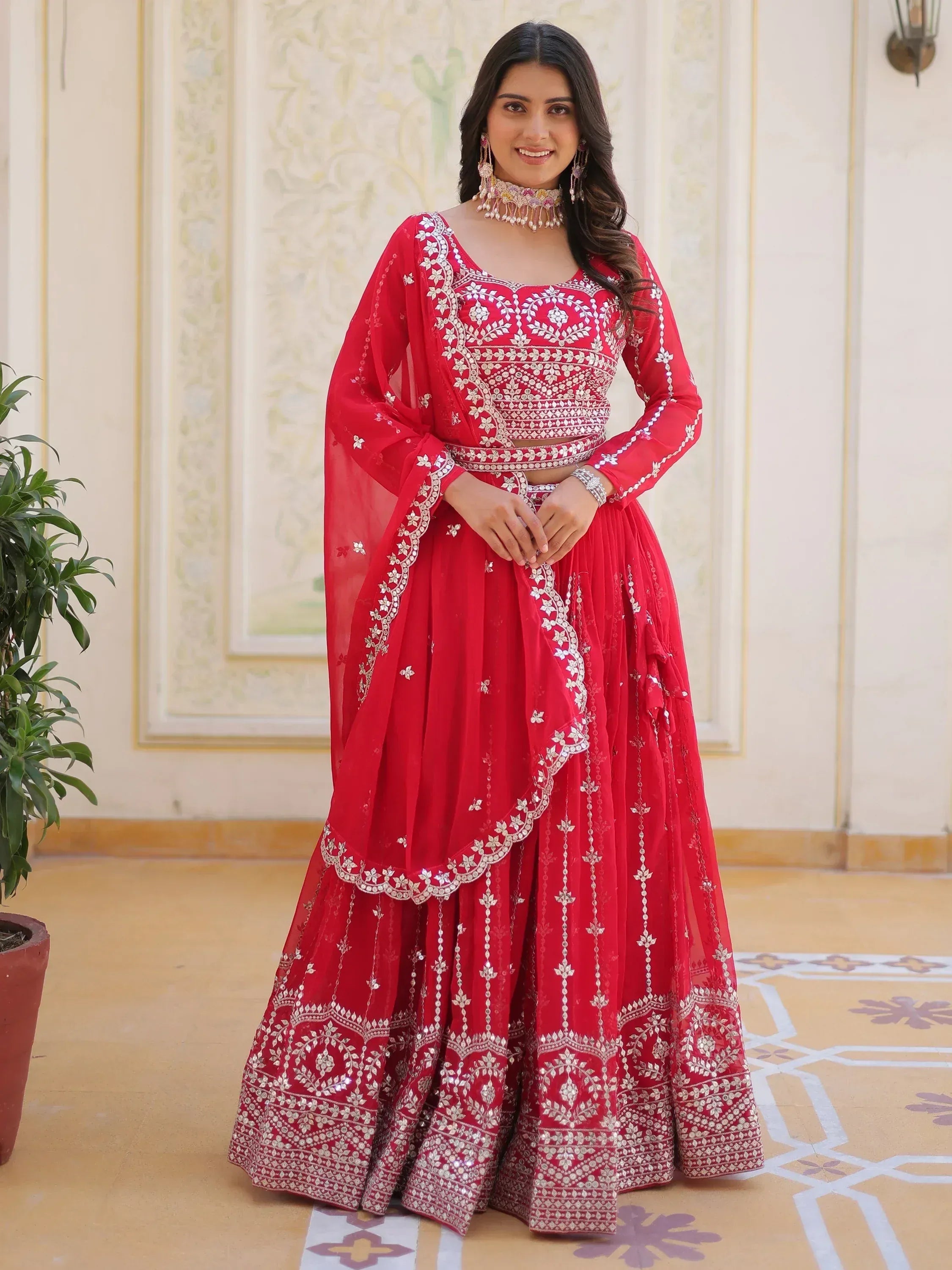 Red embroidered lehenga choli with mirror work, perfect for Indian weddings and festive occasions