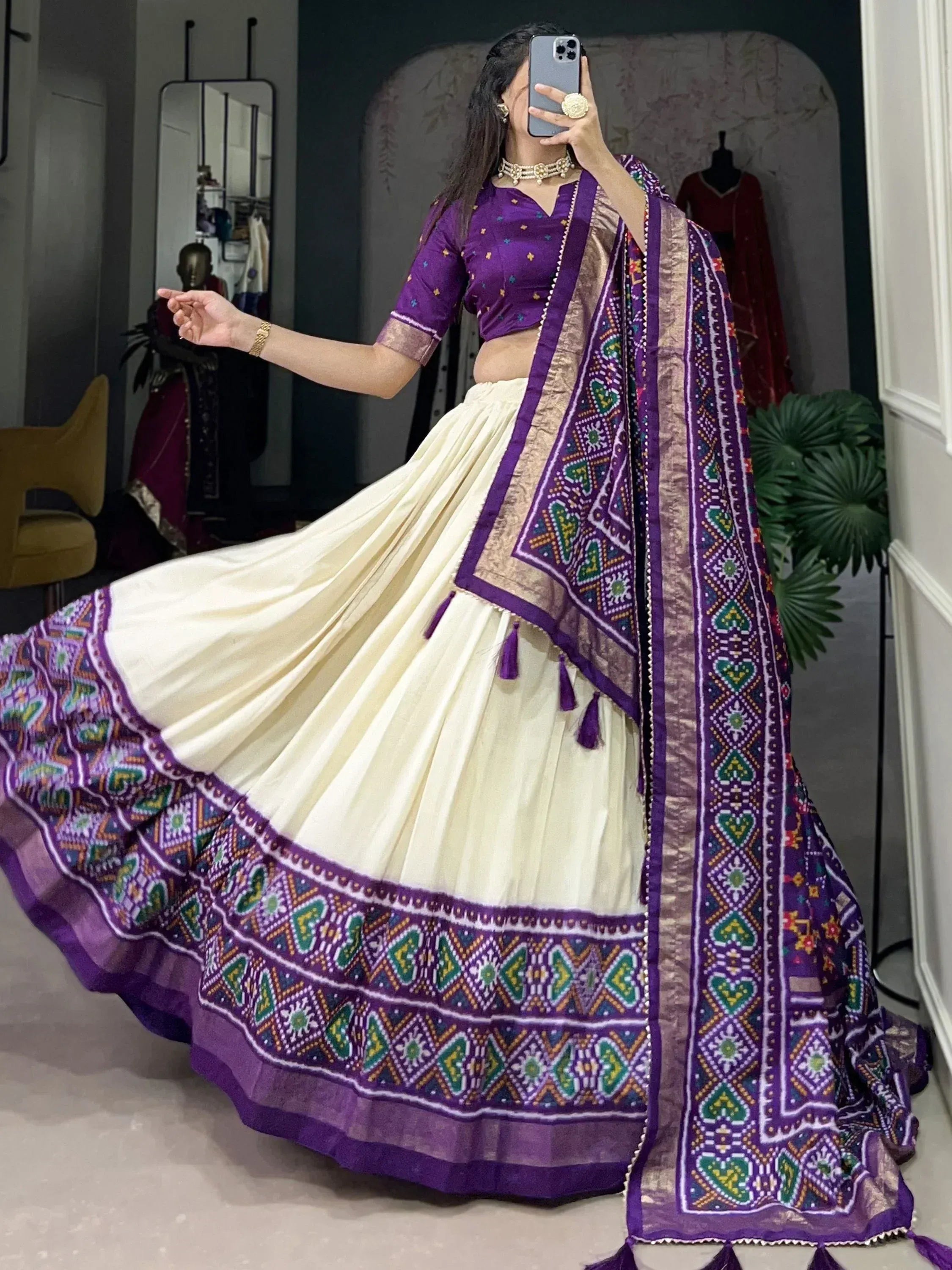 Purple and cream ethnic lehenga choli with intricate geometric print and tassels, perfect for festive occasions.