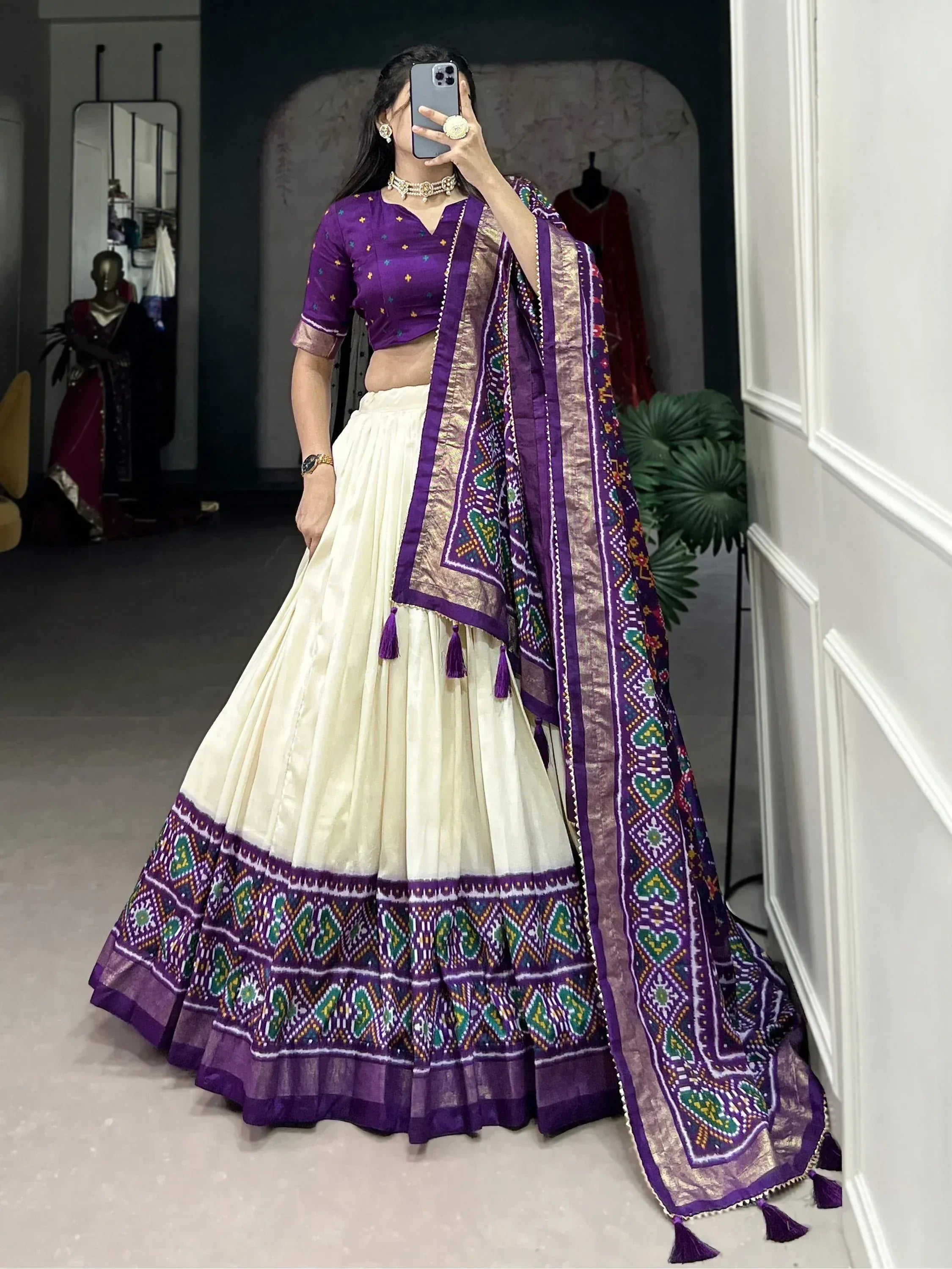 Purple and cream ethnic lehenga choli with intricate geometric print and tassels, perfect for Indian celebrations.
