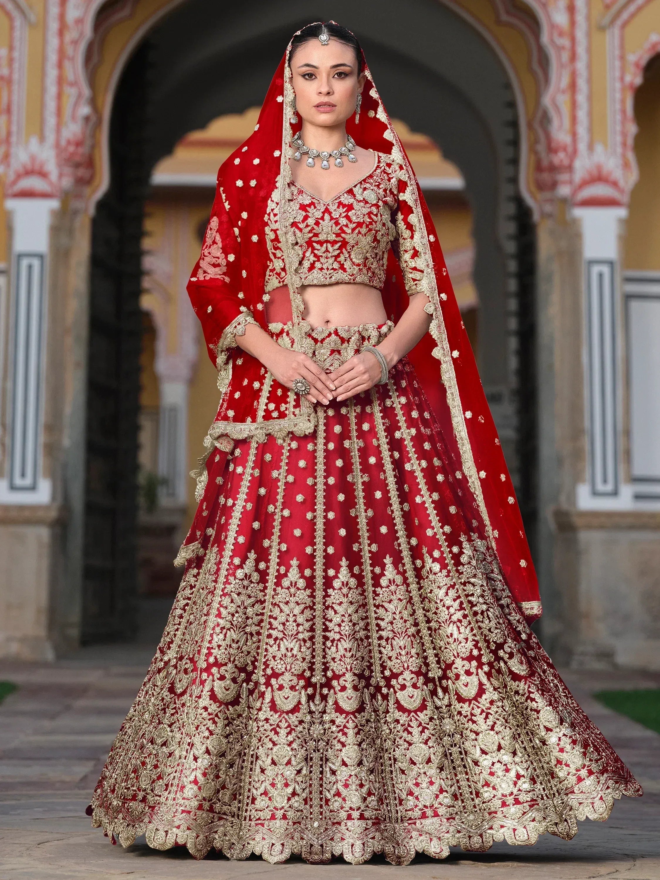 Red and gold embroidered lehenga choli with dupatta, traditional Indian bridal wear