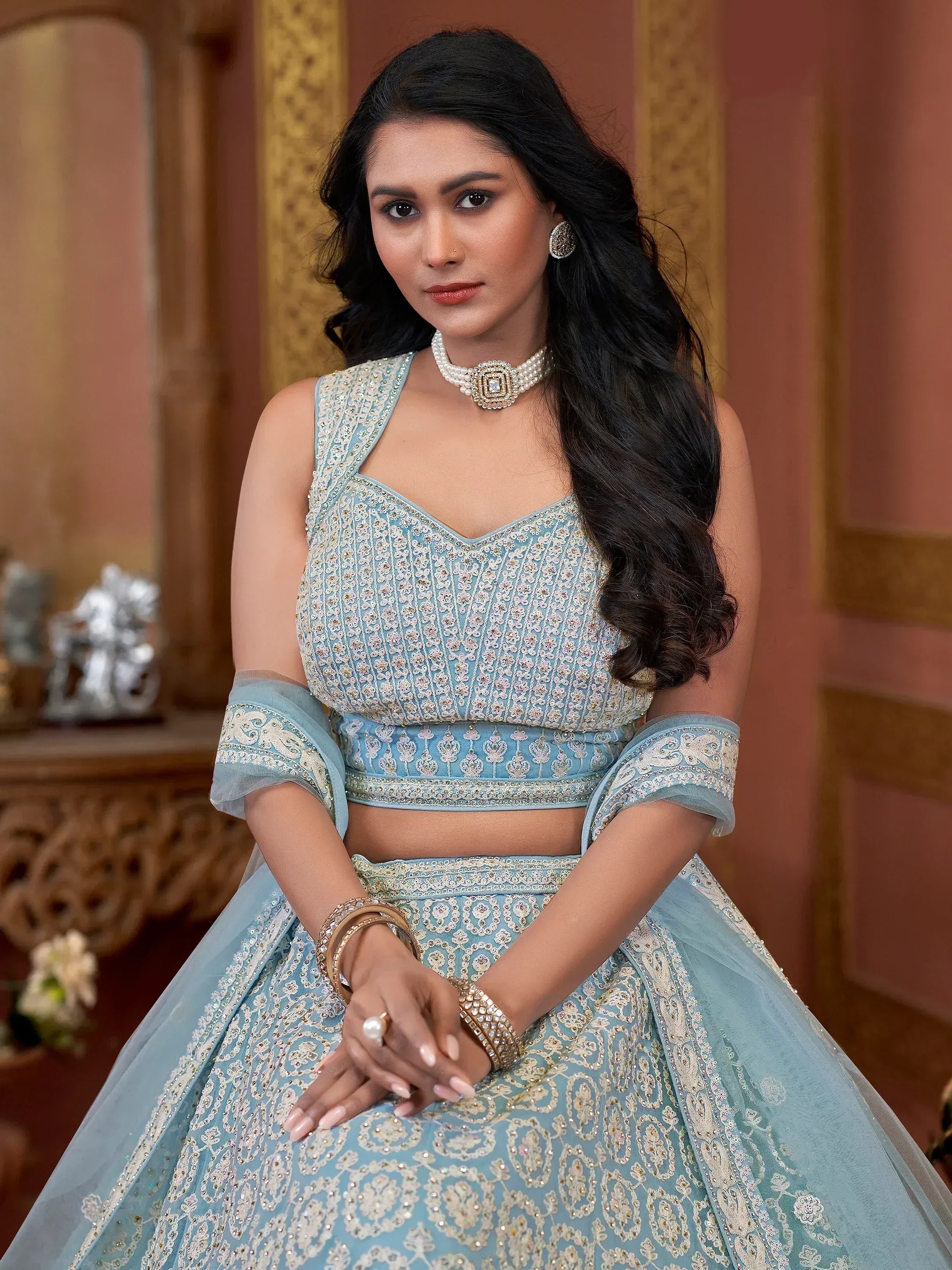 Elegant light blue embroidered lehenga choli with pearl jewelry, perfect for Indian ethnic occasions.