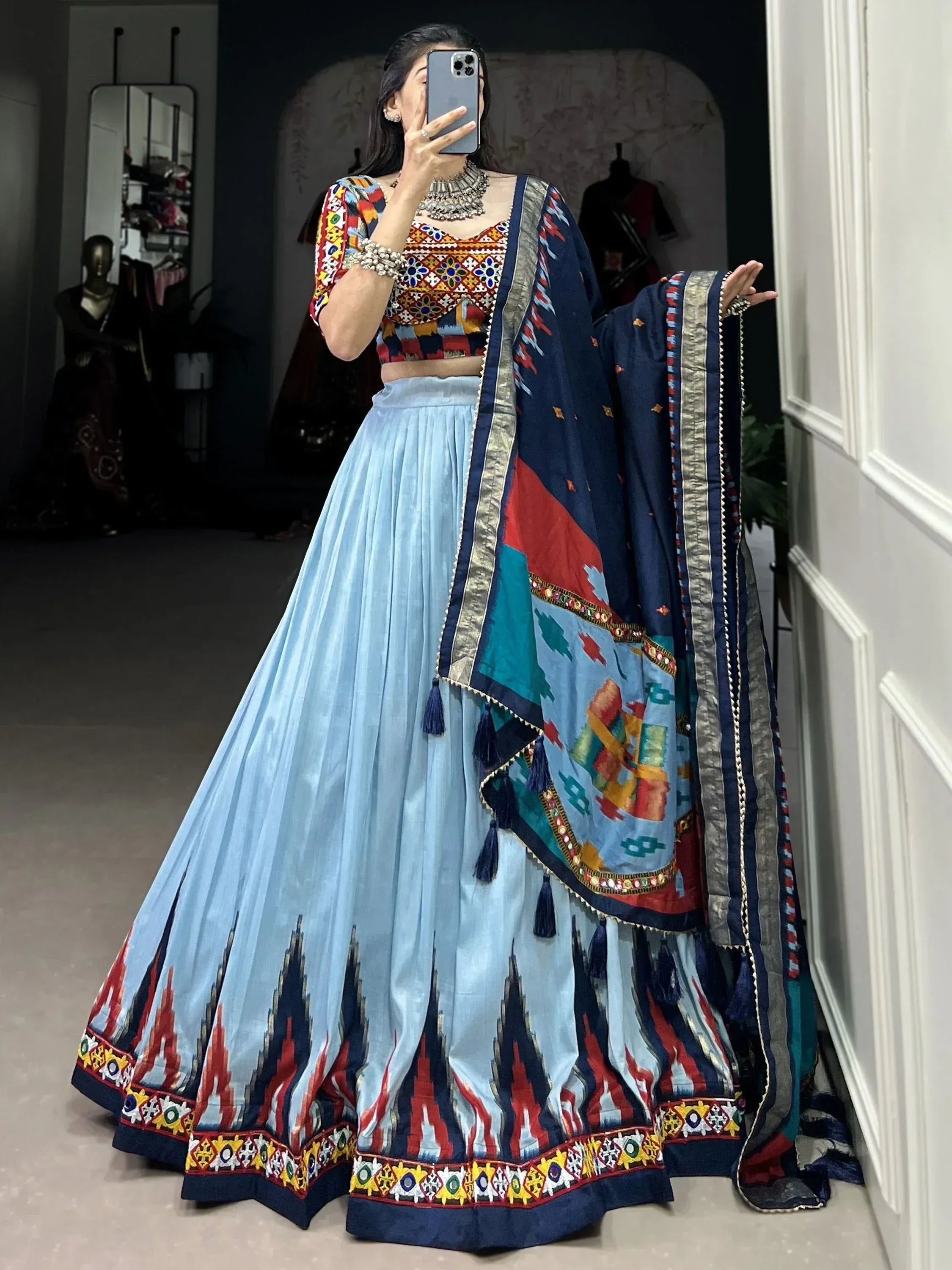 Woman wearing colorful printed lehenga choli with blue skirt and dupatta, perfect for Indian ethnic occasions