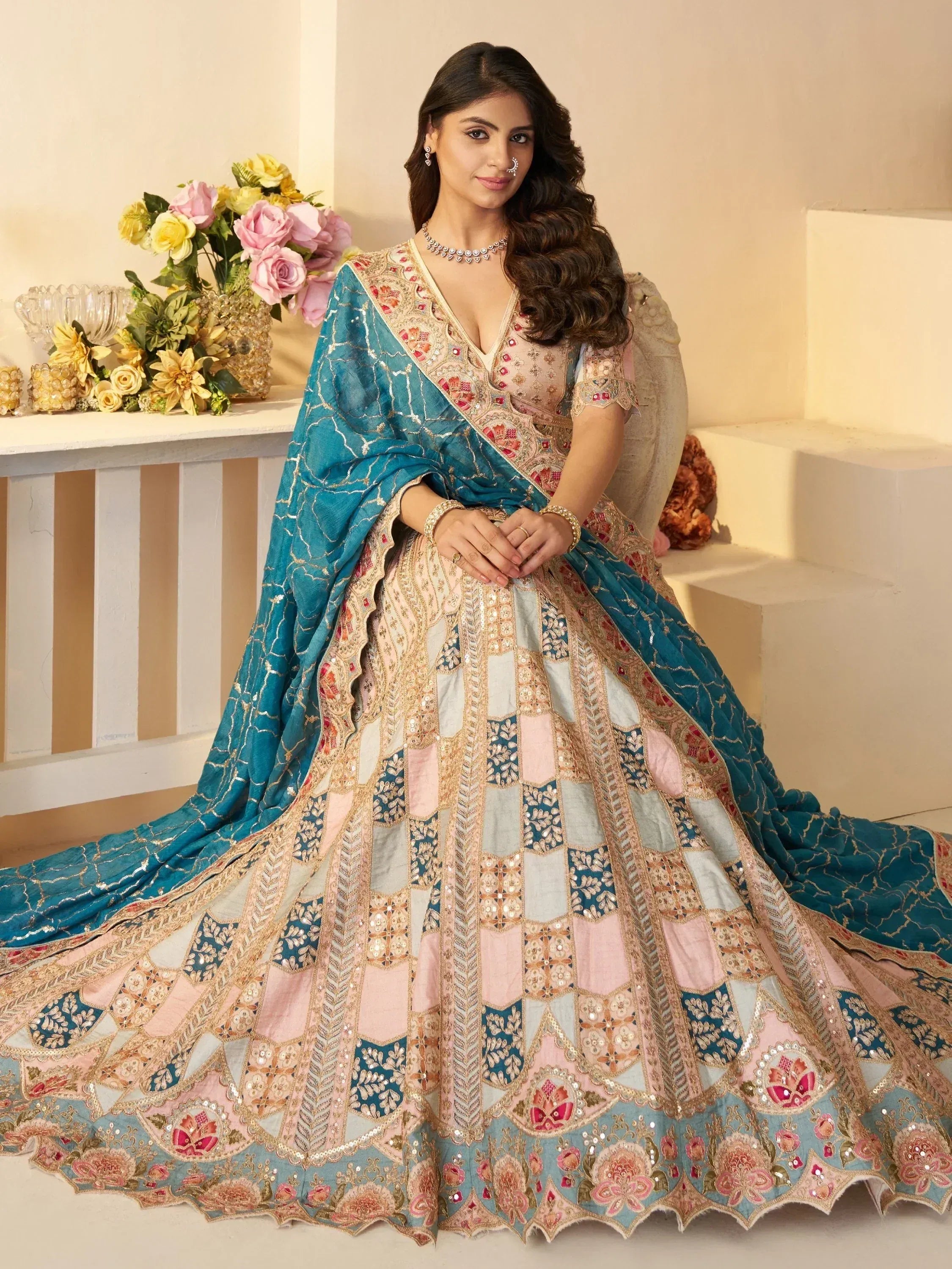 Elegant Indian designer lehenga choli with floral embroidery and teal dupatta, perfect for weddings and festivals