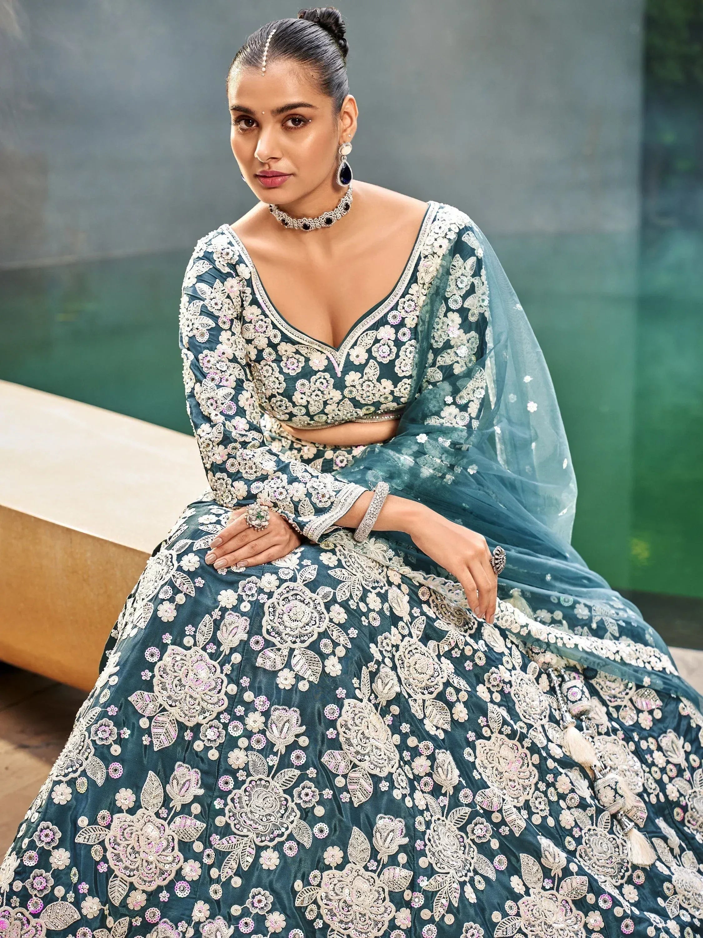 Teal designer lehenga choli with floral embroidery and sequins, perfect for Indian weddings and festive occasions.