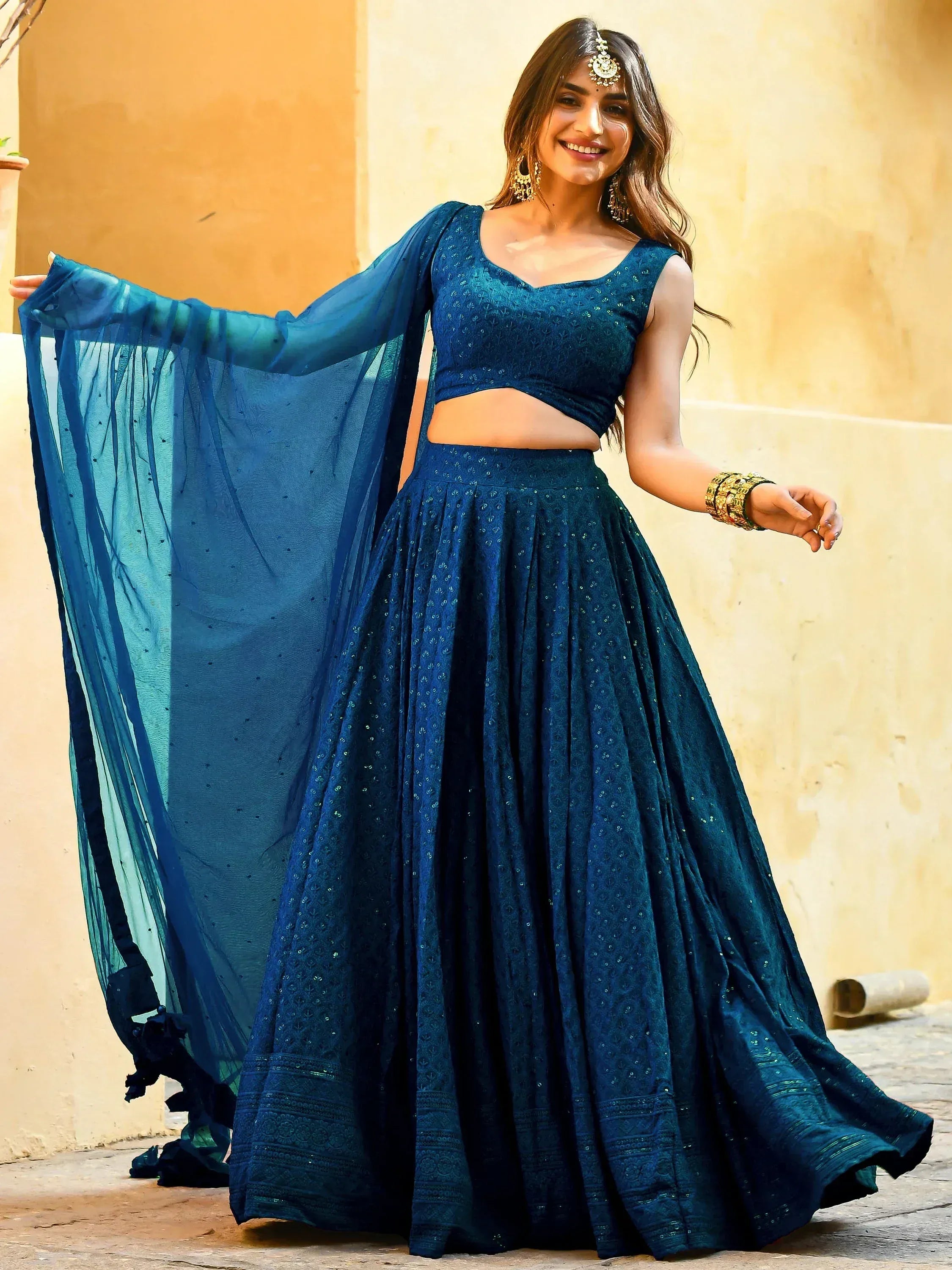 Woman in elegant blue designer lehenga choli with sheer dupatta, perfect for Indian ethnic wear occasions