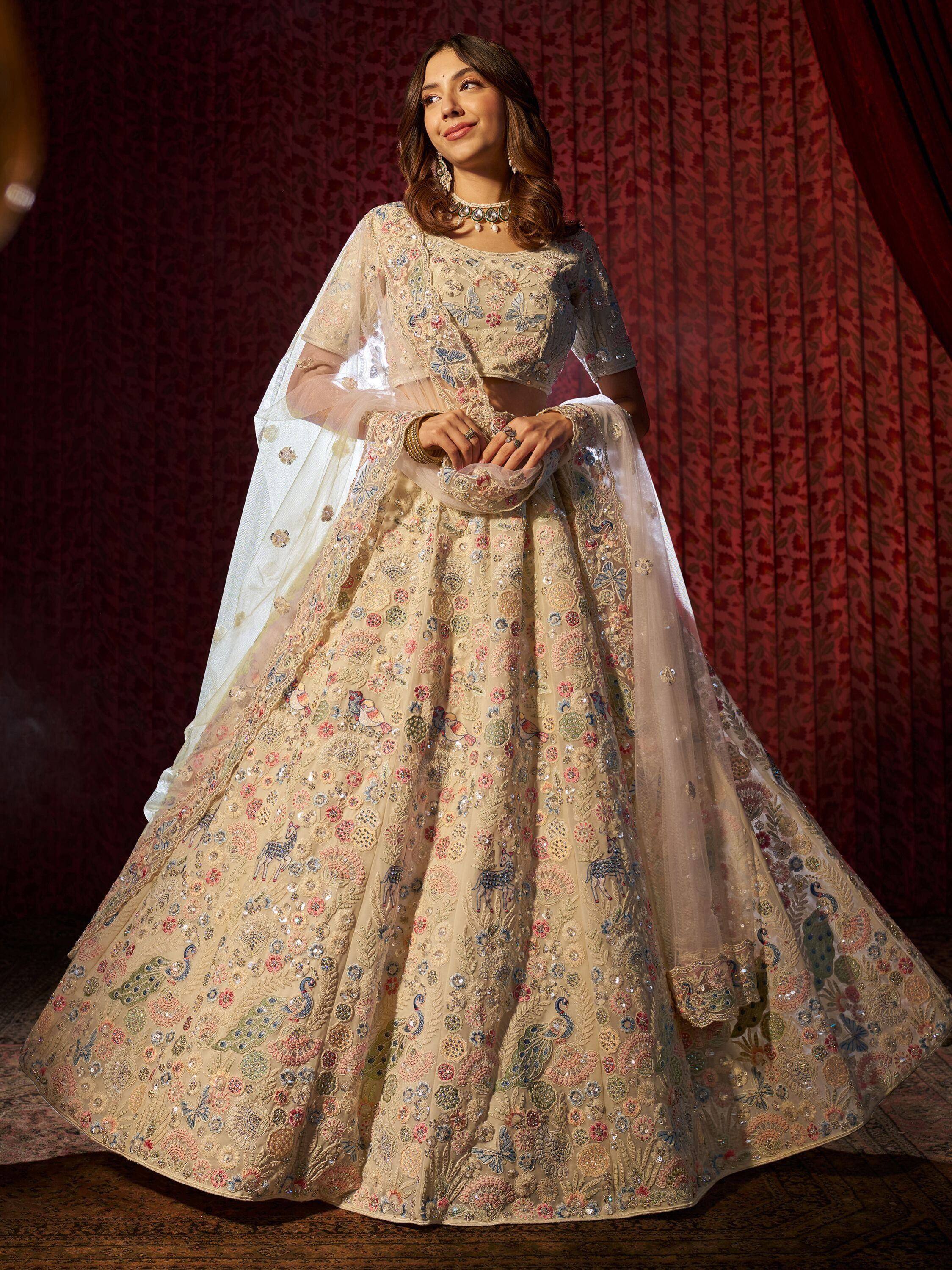 Elegant beige lehenga choli with floral and peacock embroidery, perfect for Indian weddings and festive occasions.