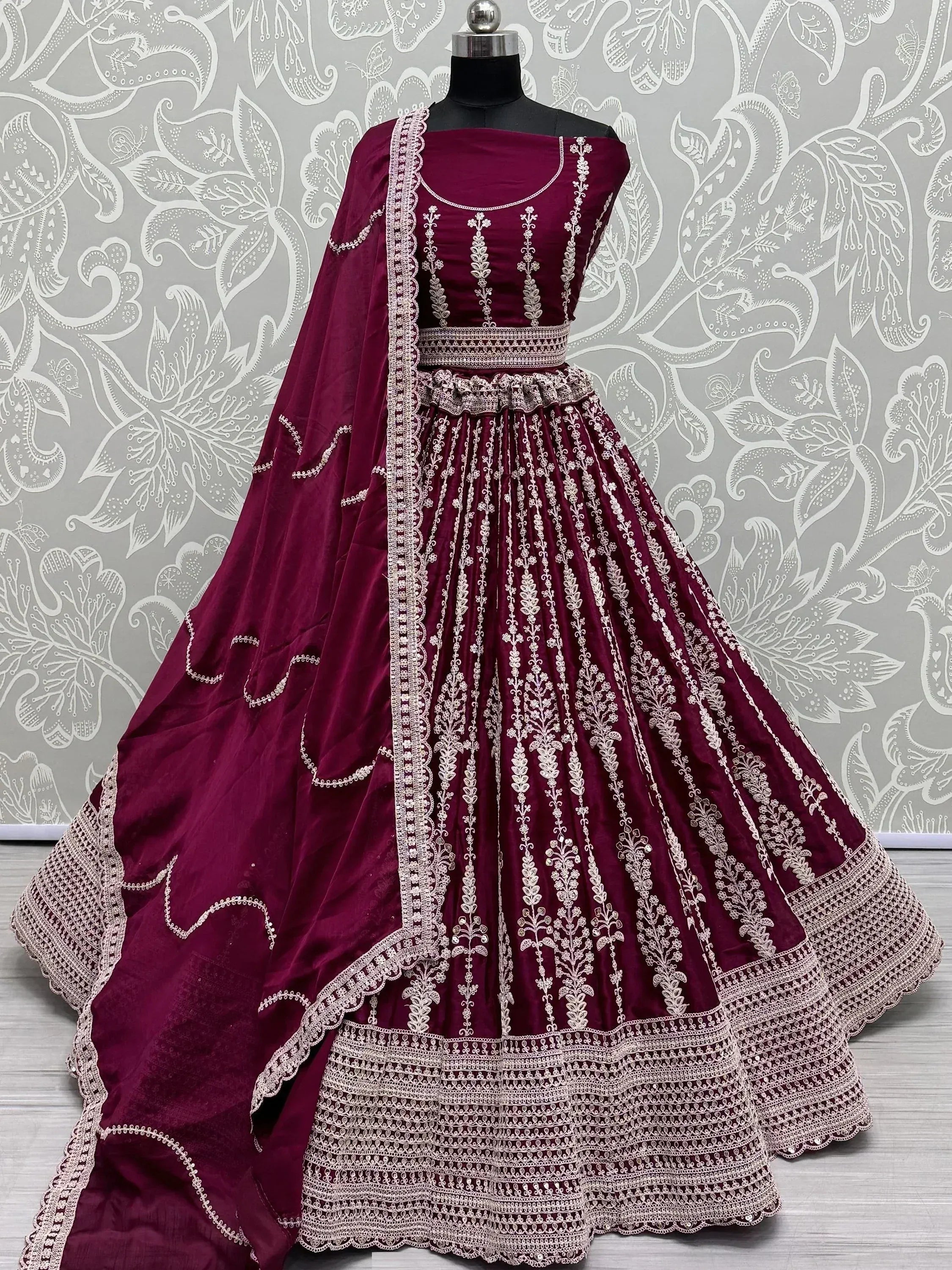Burgundy velvet lehenga choli with intricate white embroidery and matching dupatta, perfect for Indian weddings and festive occasions.