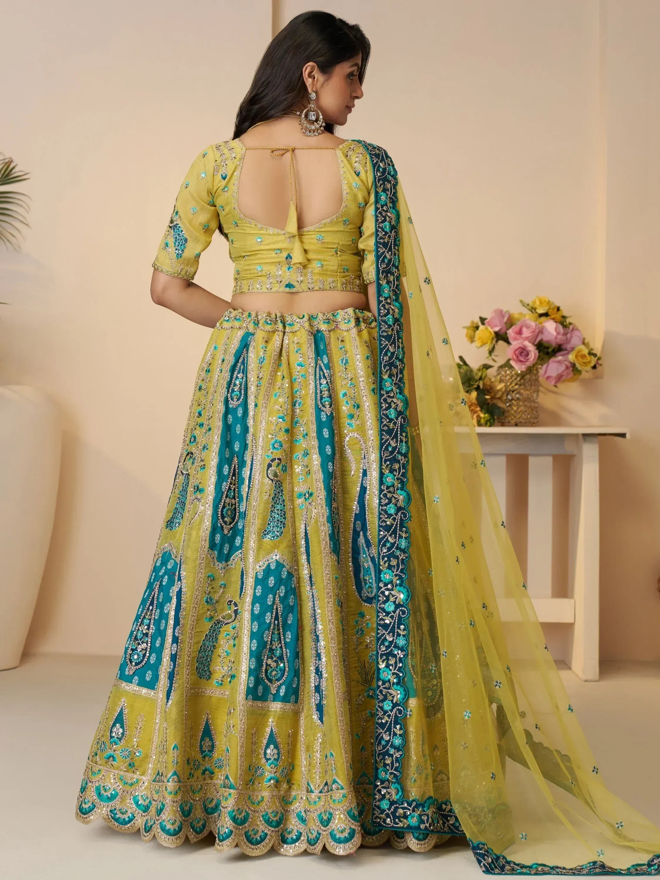 Yellow and teal embroidered lehenga choli with peacock motifs, back view, ethnic wear for women