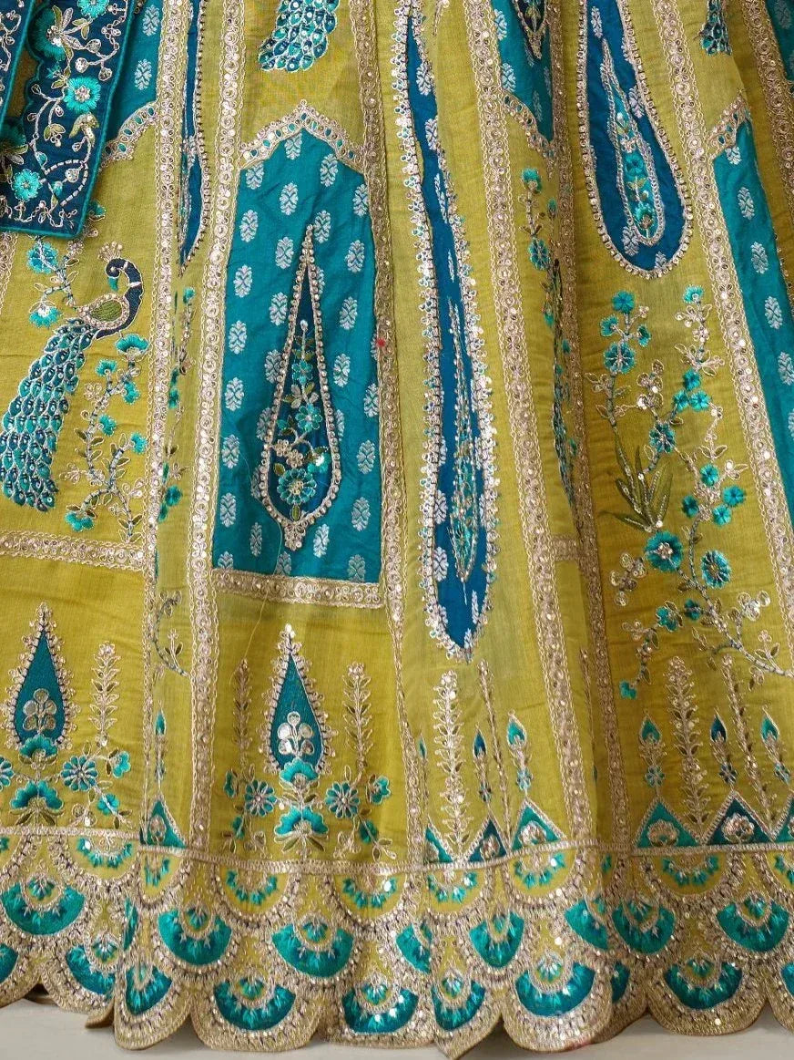 Yellow and teal embroidered lehenga with peacock motifs and gold detailing, ideal for Indian ethnic wear