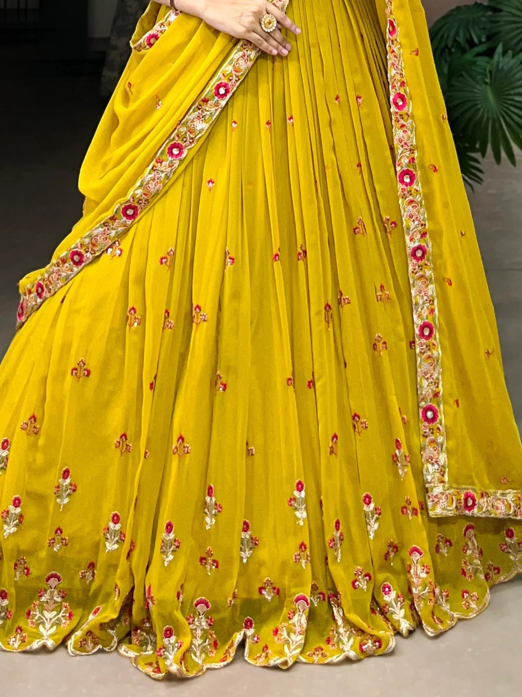 Yellow embroidered lehenga choli with floral detailing and pleated skirt, perfect for Indian ethnic wear.