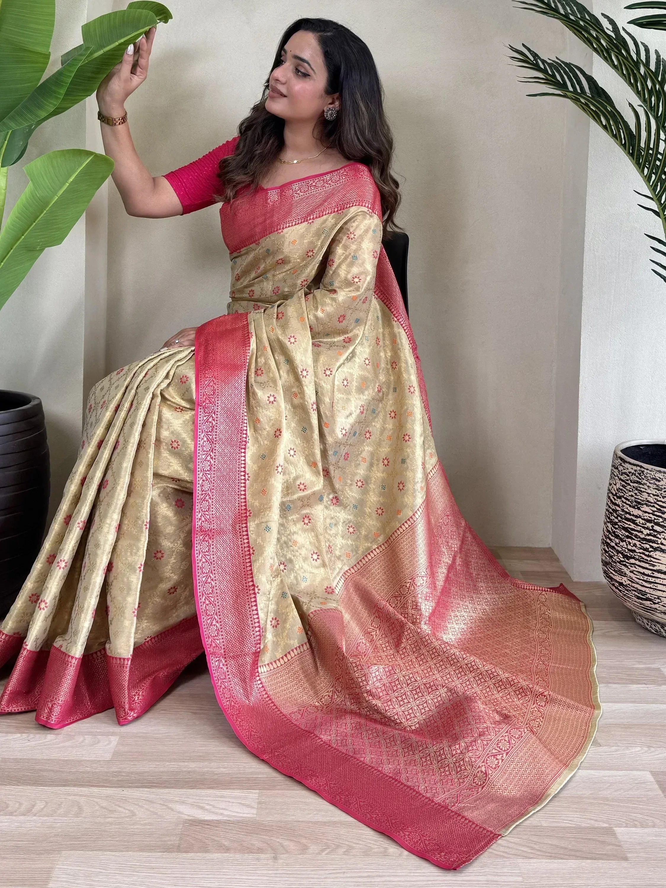 Woman in elegant gold and pink ethnic saree with floral motifs and woven border, perfect for Indian occasions