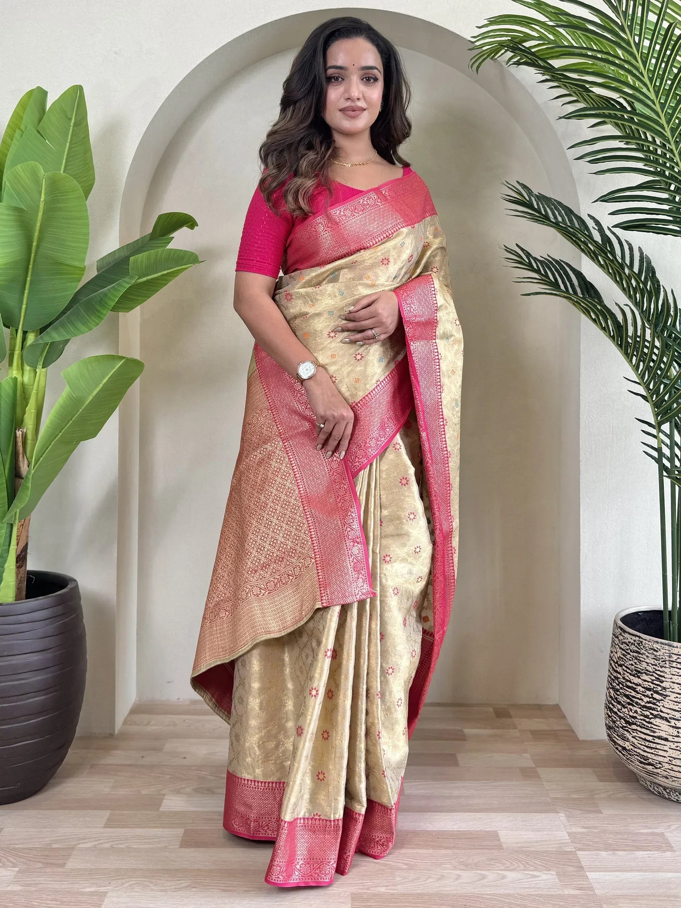 Woman in elegant gold and pink ethnic saree with intricate patterns, perfect for Indian occasions