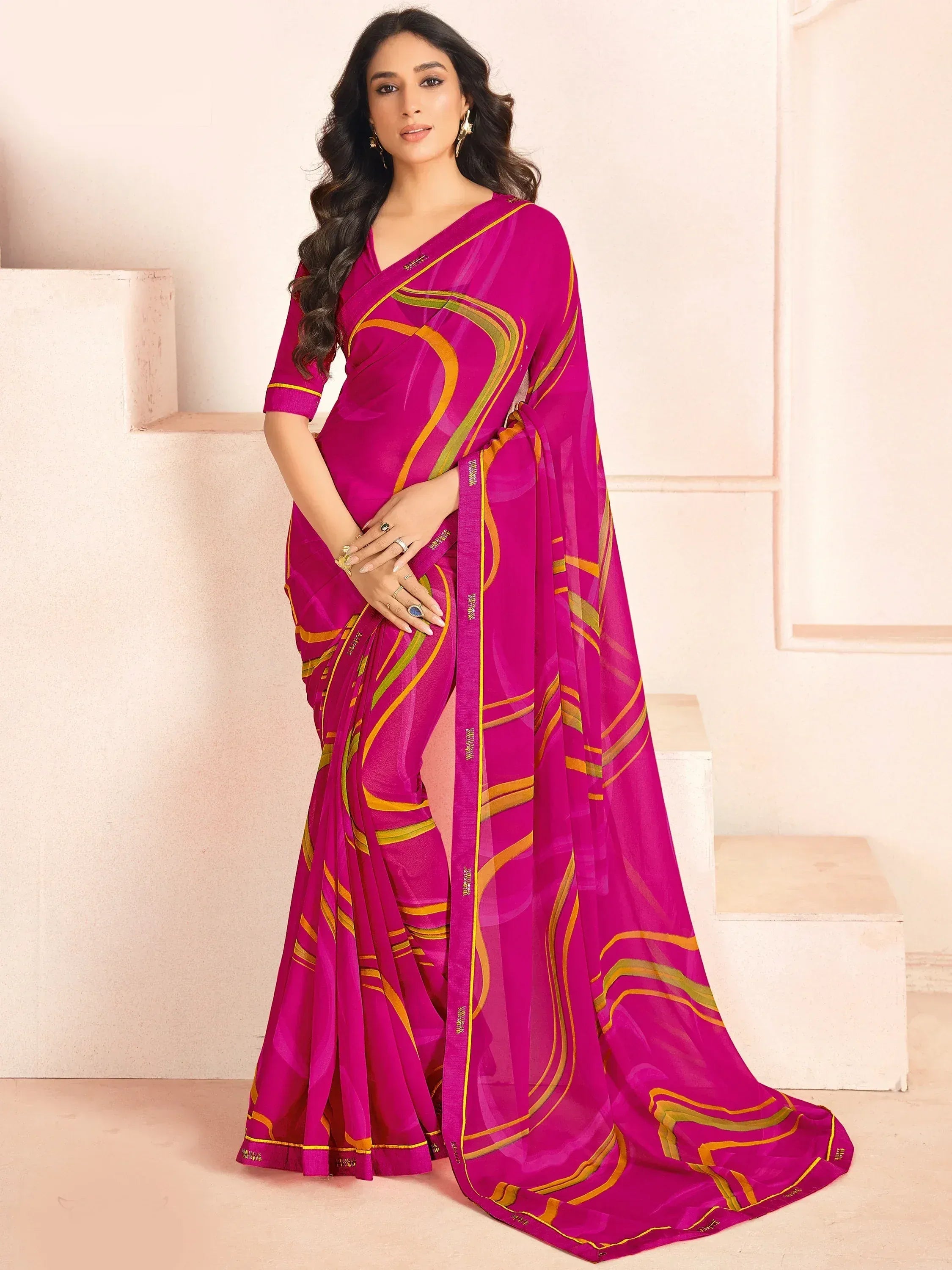 Vibrant magenta saree with gold and green abstract stripes, styled with matching blouse for ethnic wear