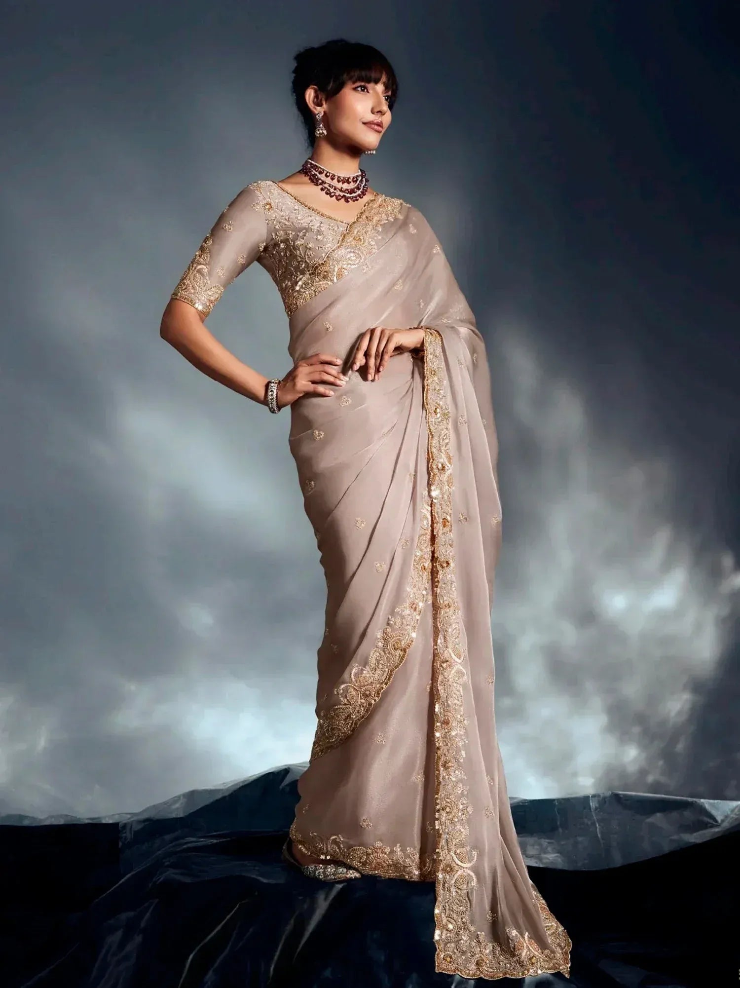 Elegant beige saree with gold embroidery, perfect for Indian ethnic wear occasions.