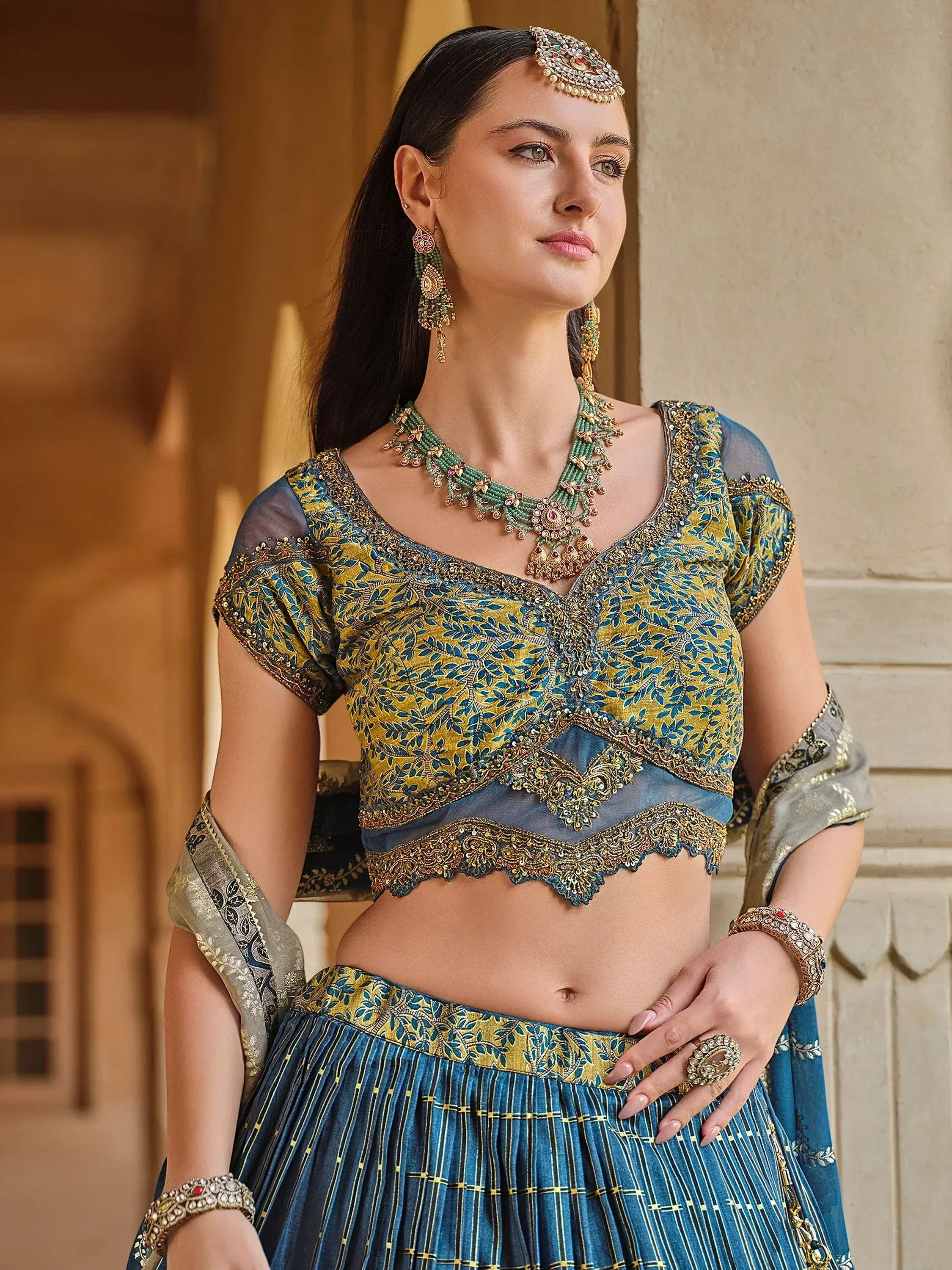 Blue and gold embroidered lehenga choli with matching jewelry for Indian ethnic wear